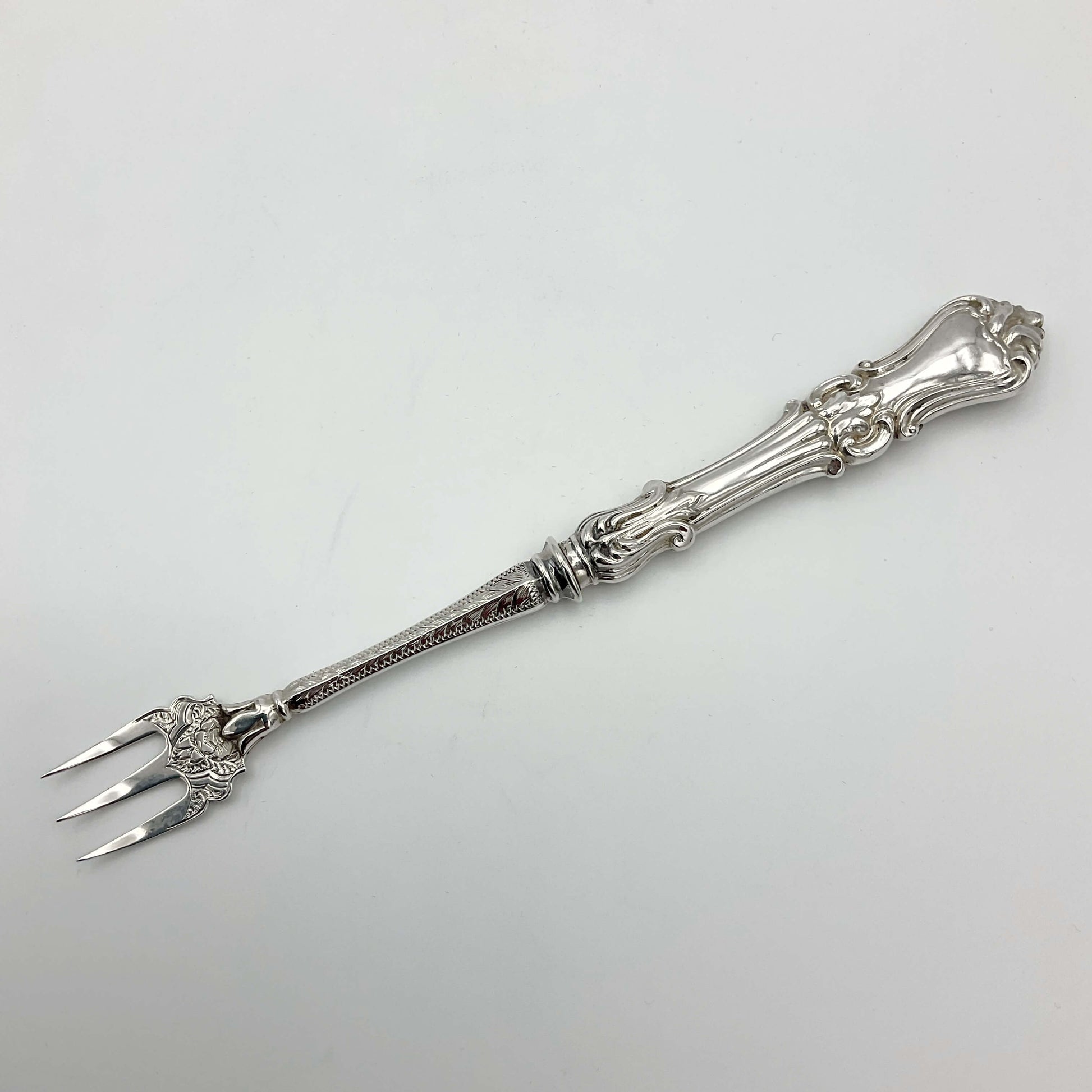Beautiful ornate antique pickle fork on white background