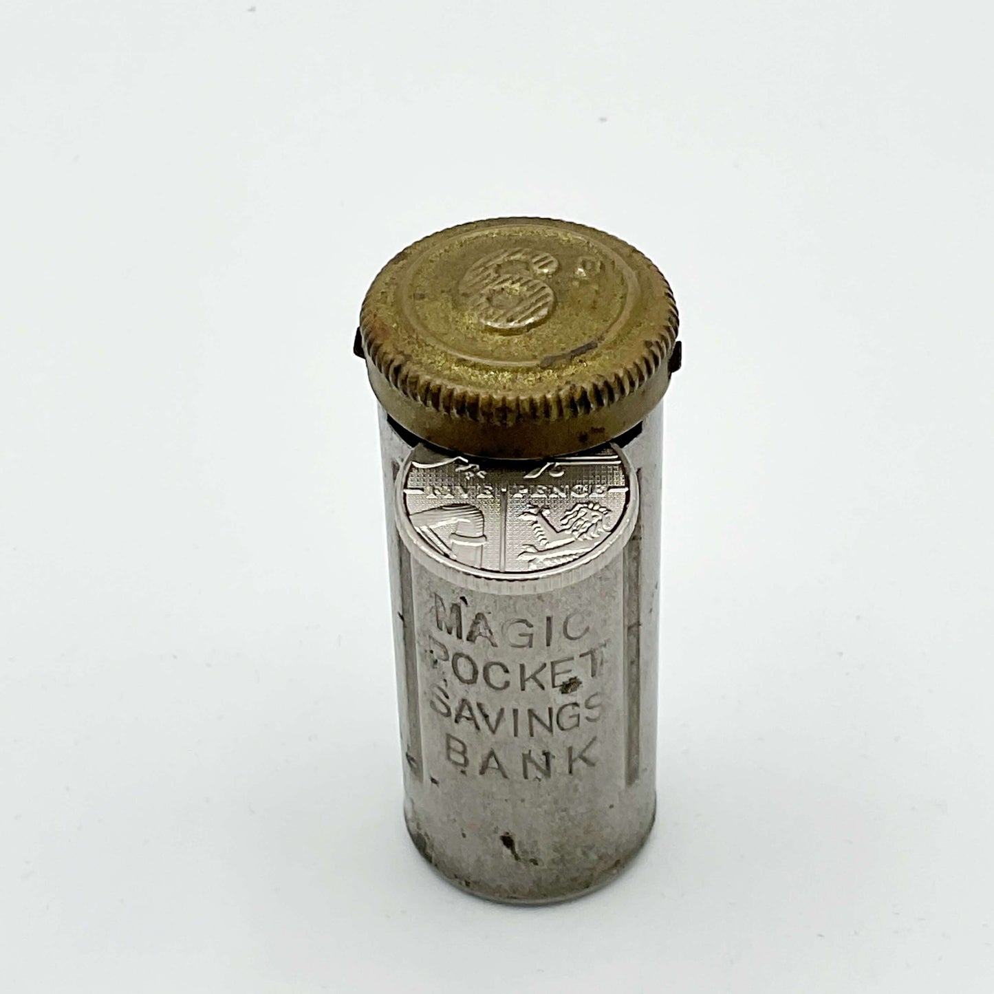 Vintage coin holder called the Magic Pocket Savings Bank with a 5p coin in the slot waiting to be pushed into the holder