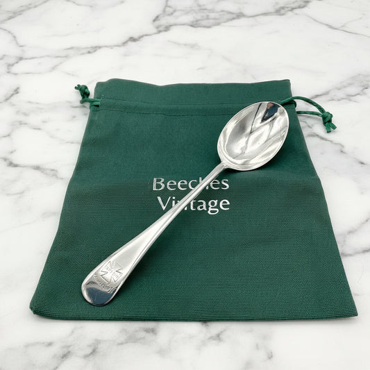 Antique Silver plated spoon with Marjorie on the handle on a green gift bag on marble