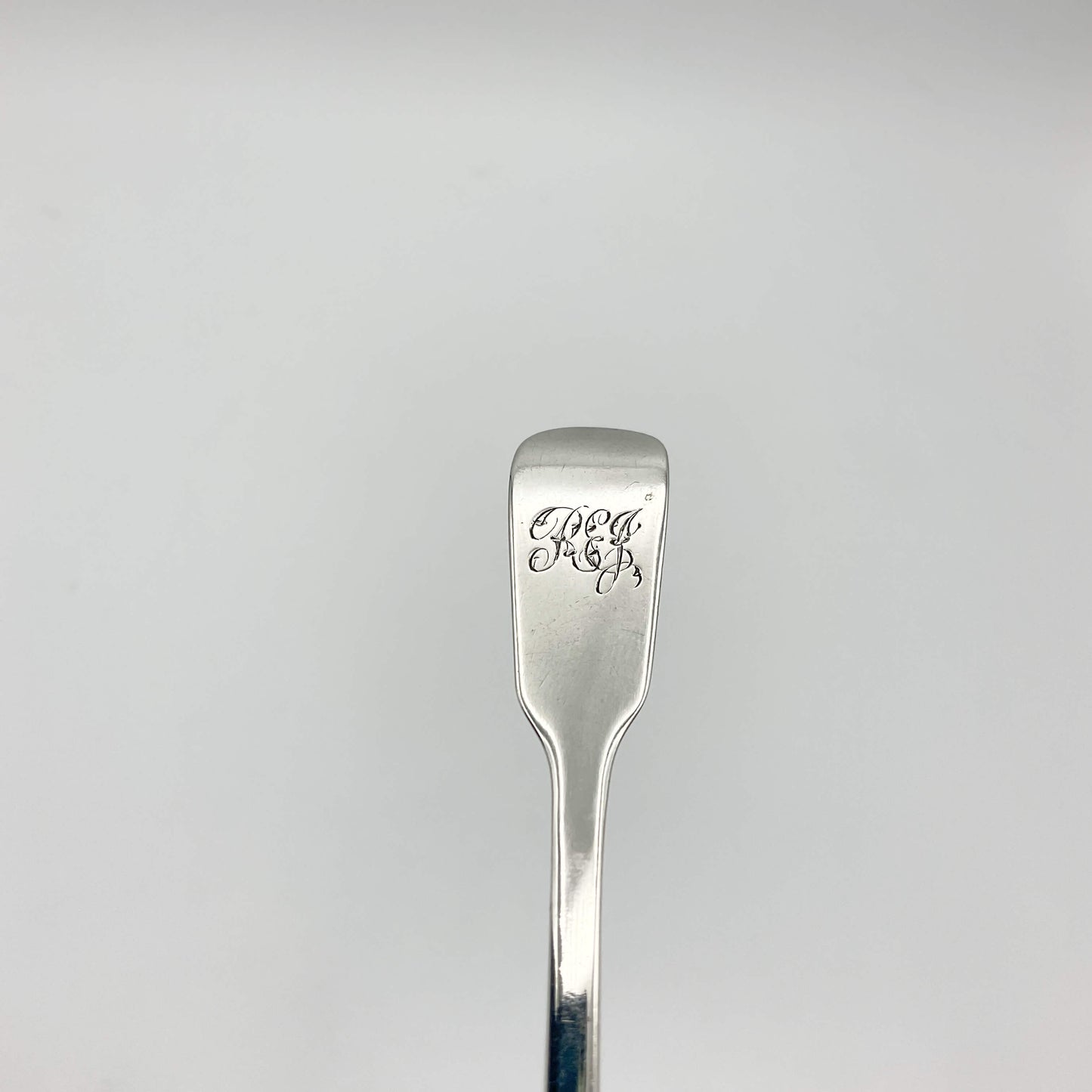 Antique silver condiment spoon handle with REJ engraved at the top