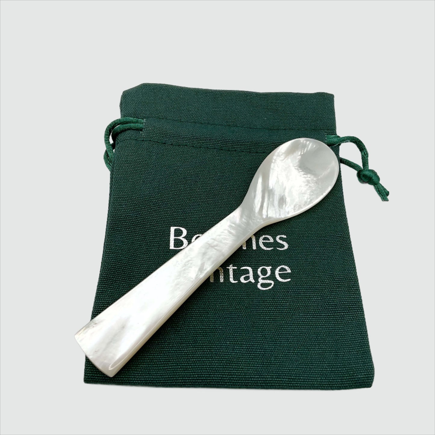 Mother of Pearl caviar spoon on a green gift bag