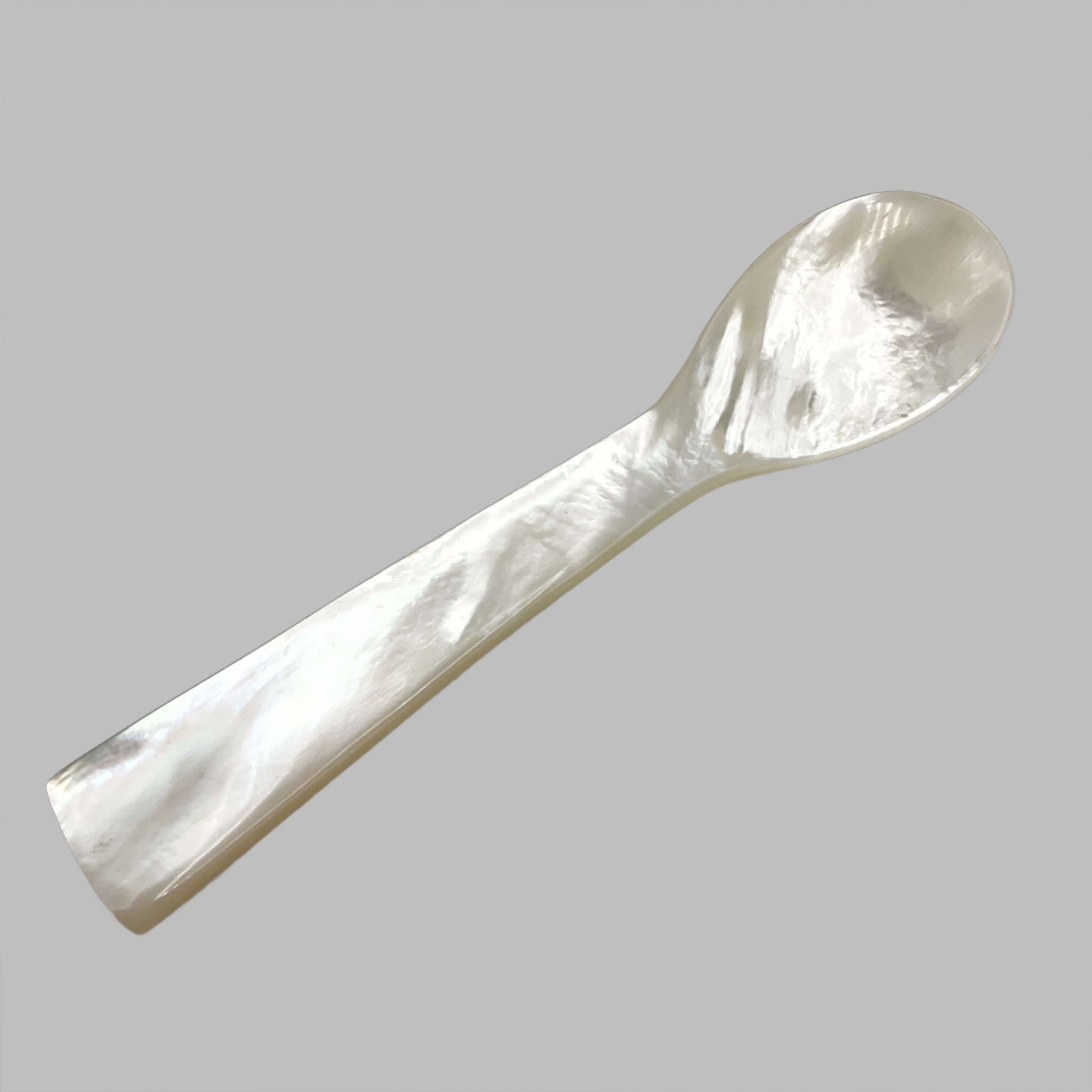 Beautiful mother of pearl spoon on a white background