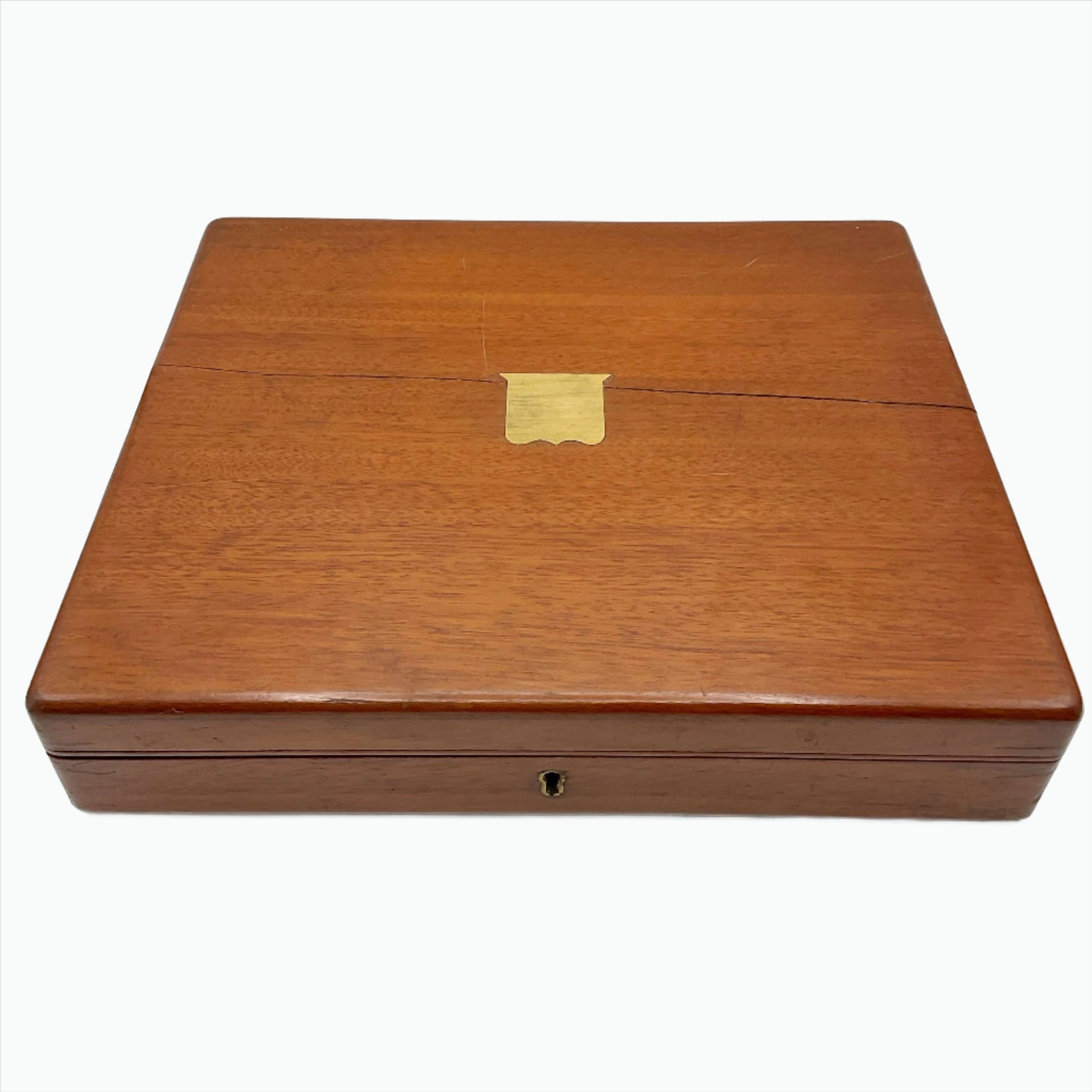 Antique wooden box with a brass shield in the centre on a white background