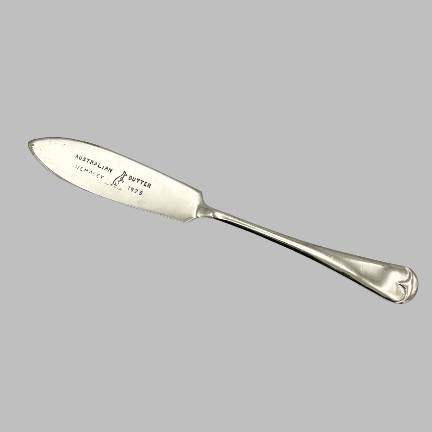 Silver plated butter knife with Australian Butter Wembley 1925 on the blade with a Kangaroo emblem on a white background