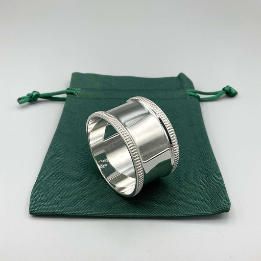 Shiny silver napkin ring on a green cotton gift bag