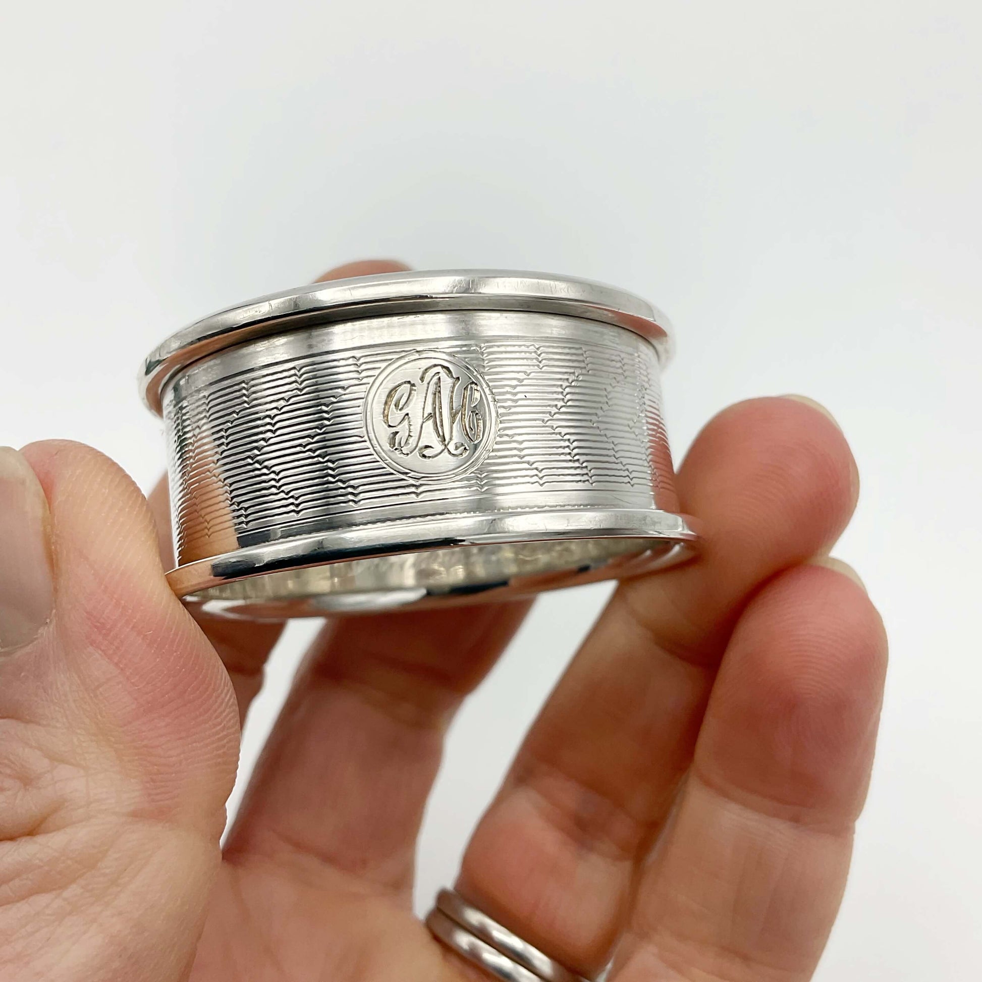 Silver napkin ring held in a hand