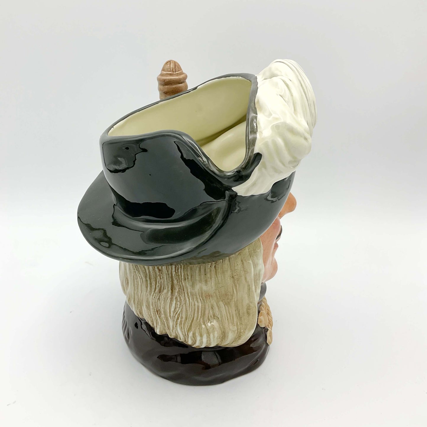 Side view of Large Aramis China collectible toby jug on plain background.