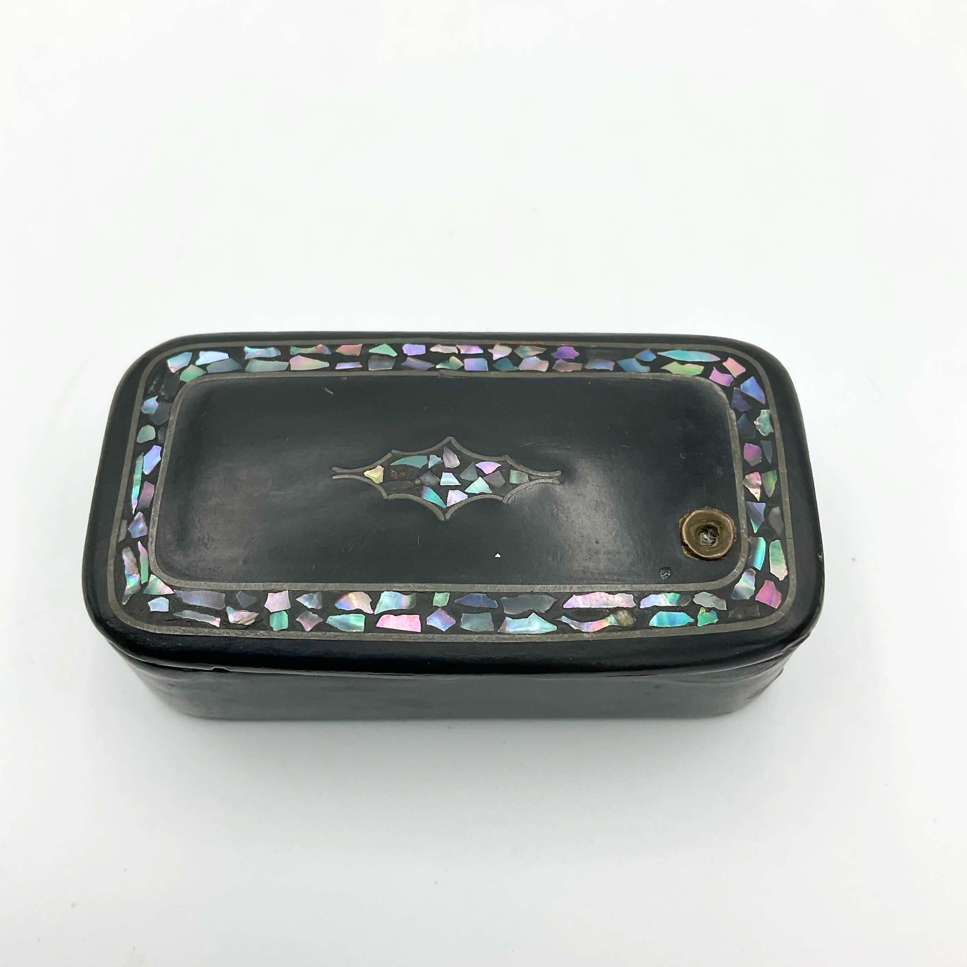 Antique black lacquer snuff box with multicoloured shell inlay on a plain background 