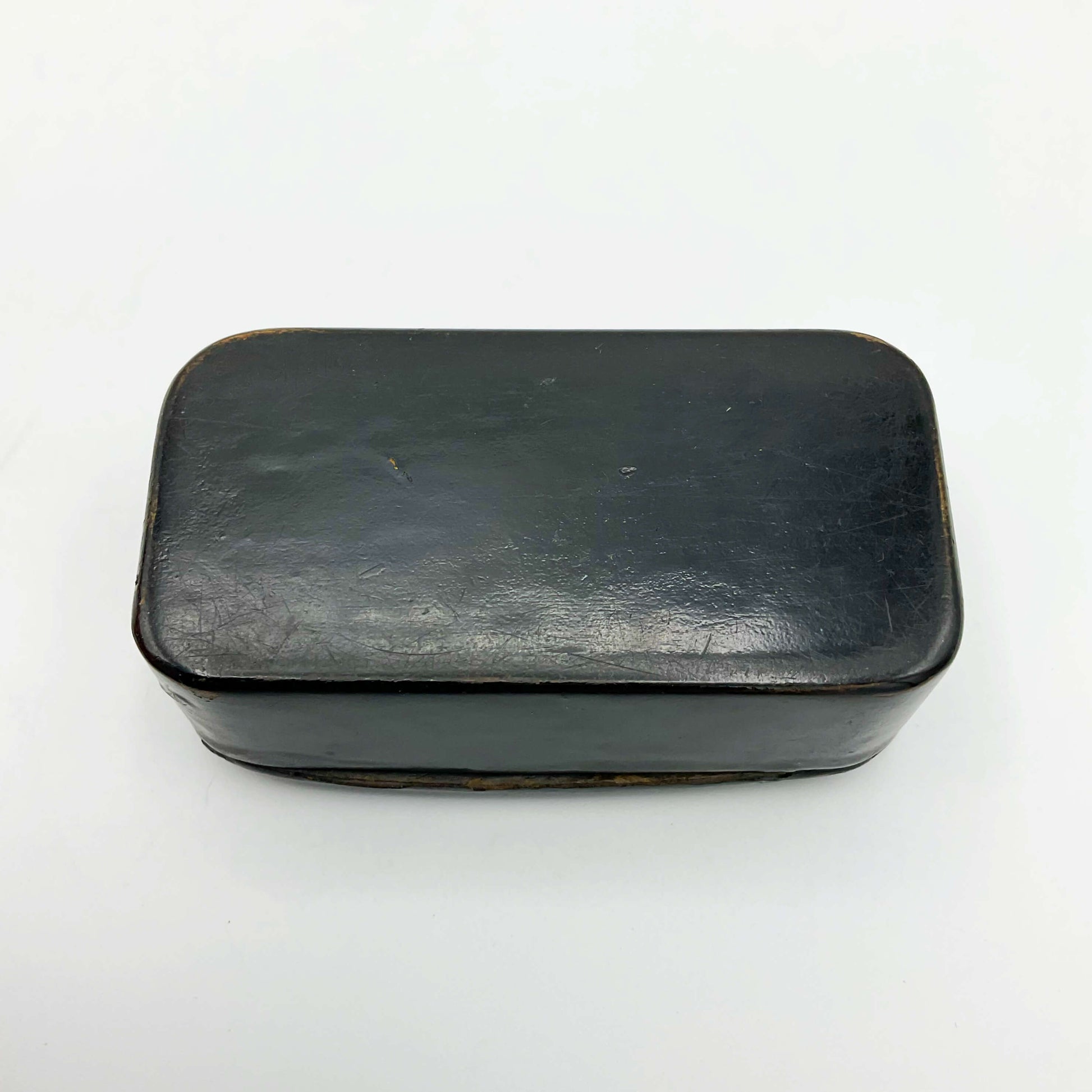 Base of Antique Black lacquer snuff box on a white background