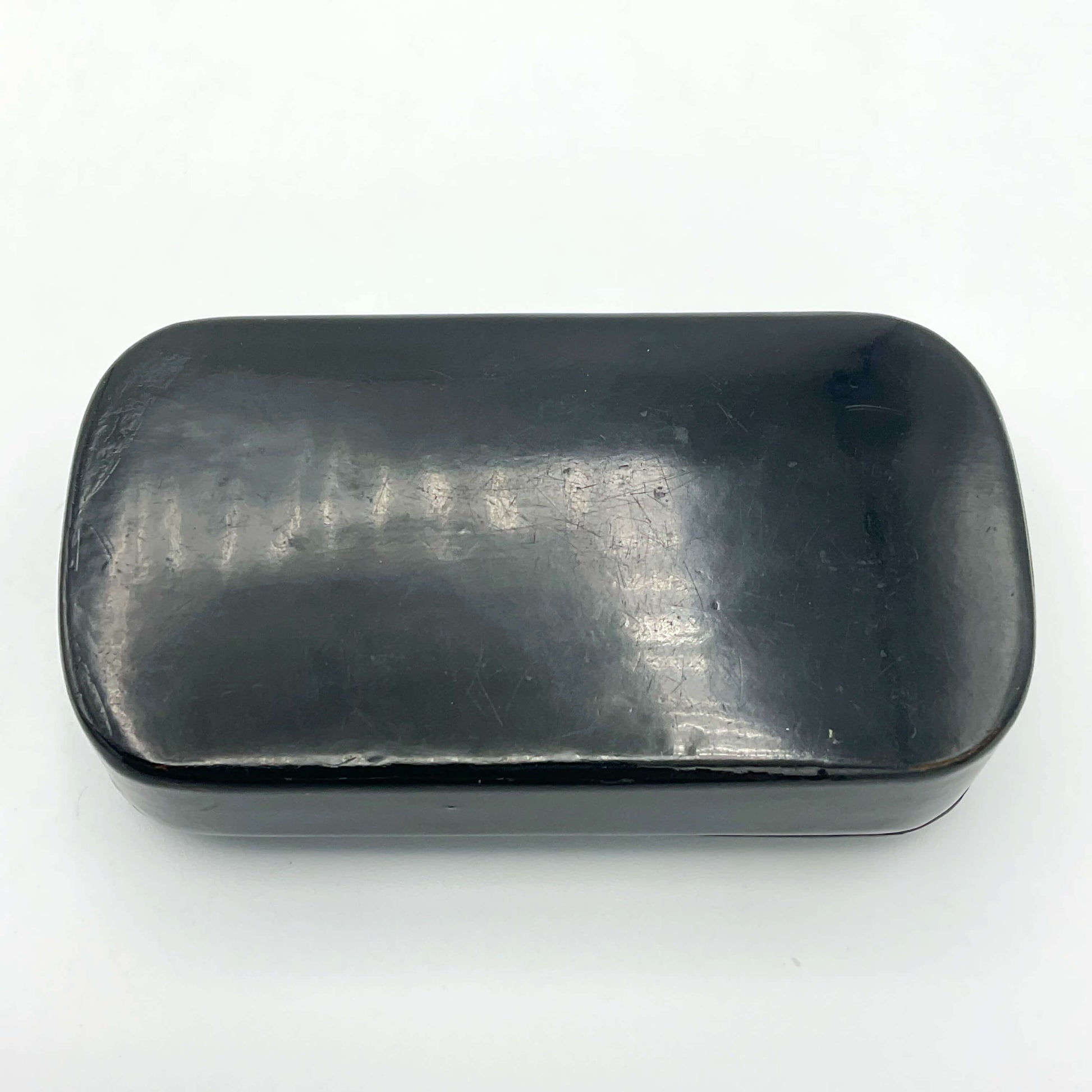 Black base of snuff box on a plain background 