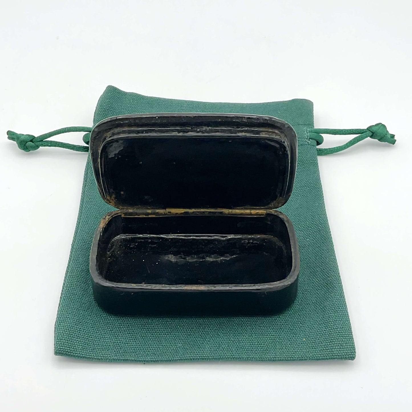 Antique black lacquer and gold snuff box showing the inside on a gift bag