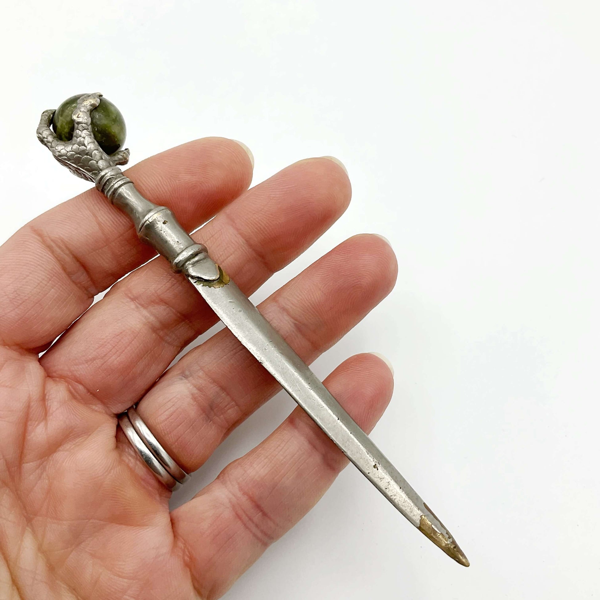 Sword shaped vintage silver plated letter knife held in a hand