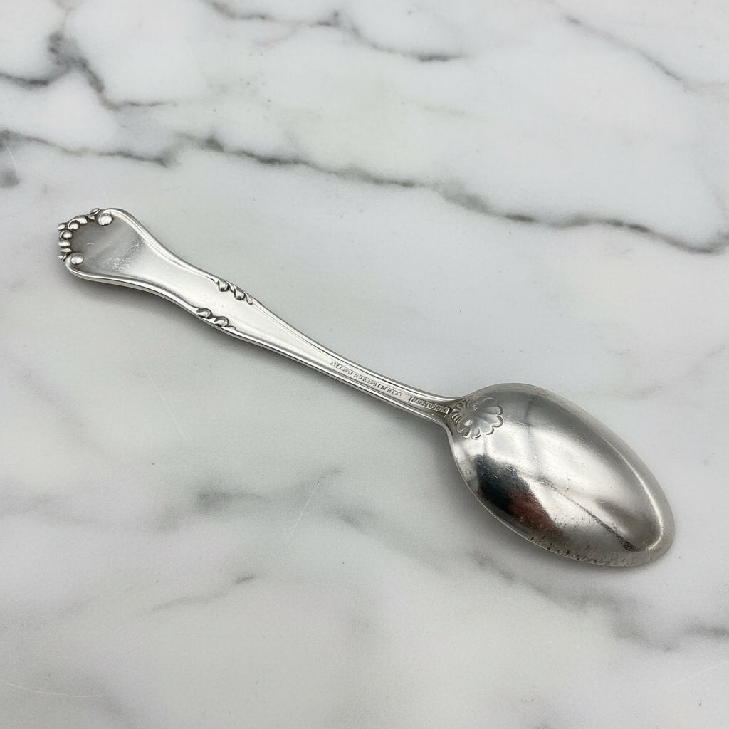 silver plated spoon upside down on a marble worktop