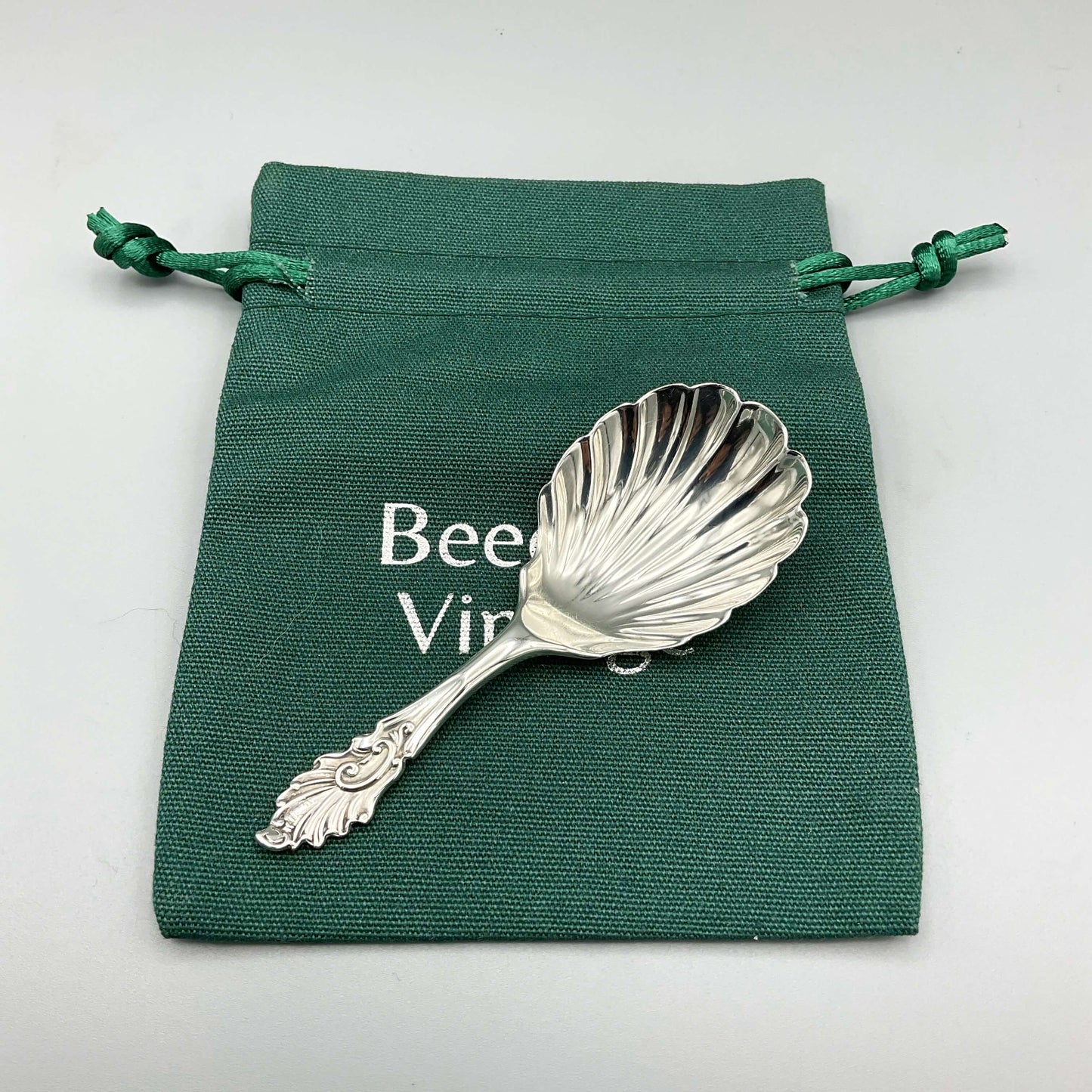 Silver caddy spoon on a green bag