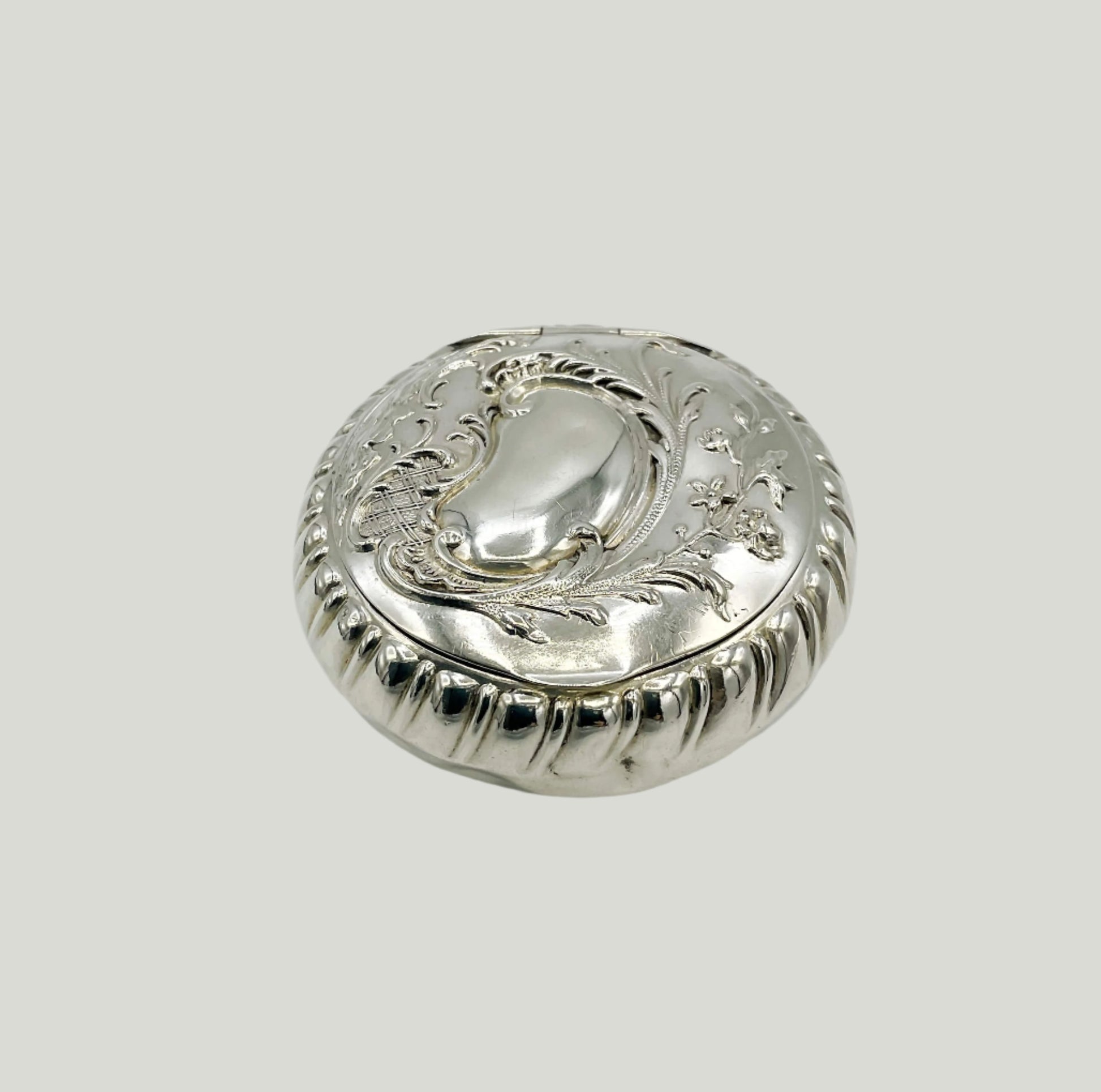 Embossed silver pill box on a white background 