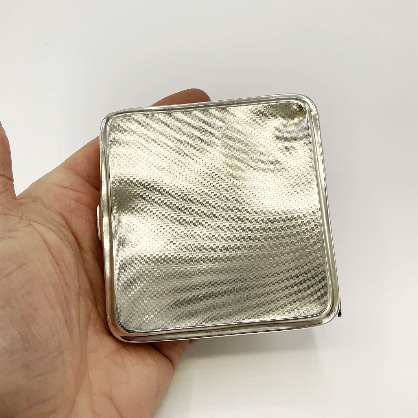 Back view of Silver Cigarette Case in a hand