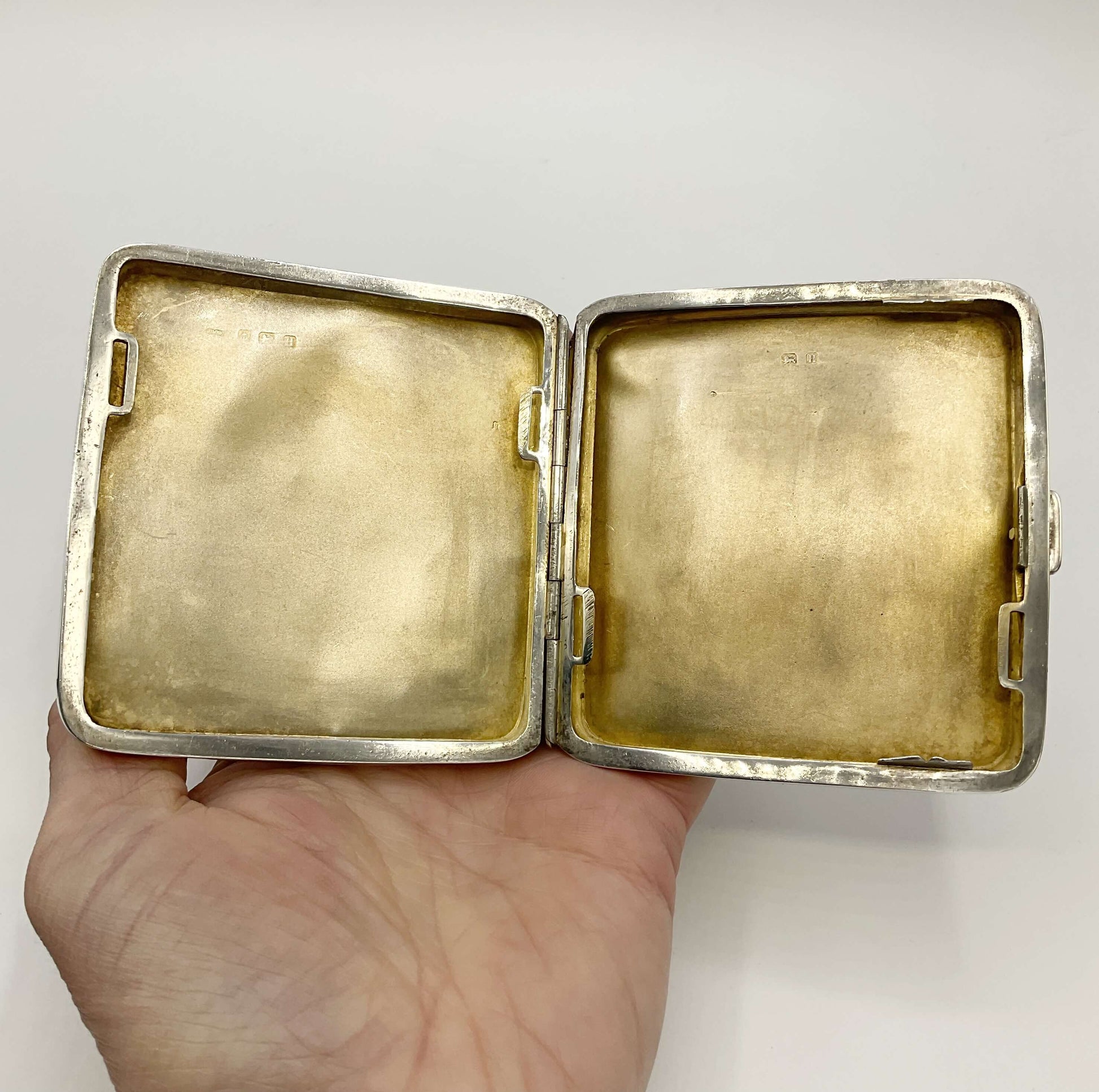 View of gilded inside of Silver Cigarette Case in a hand