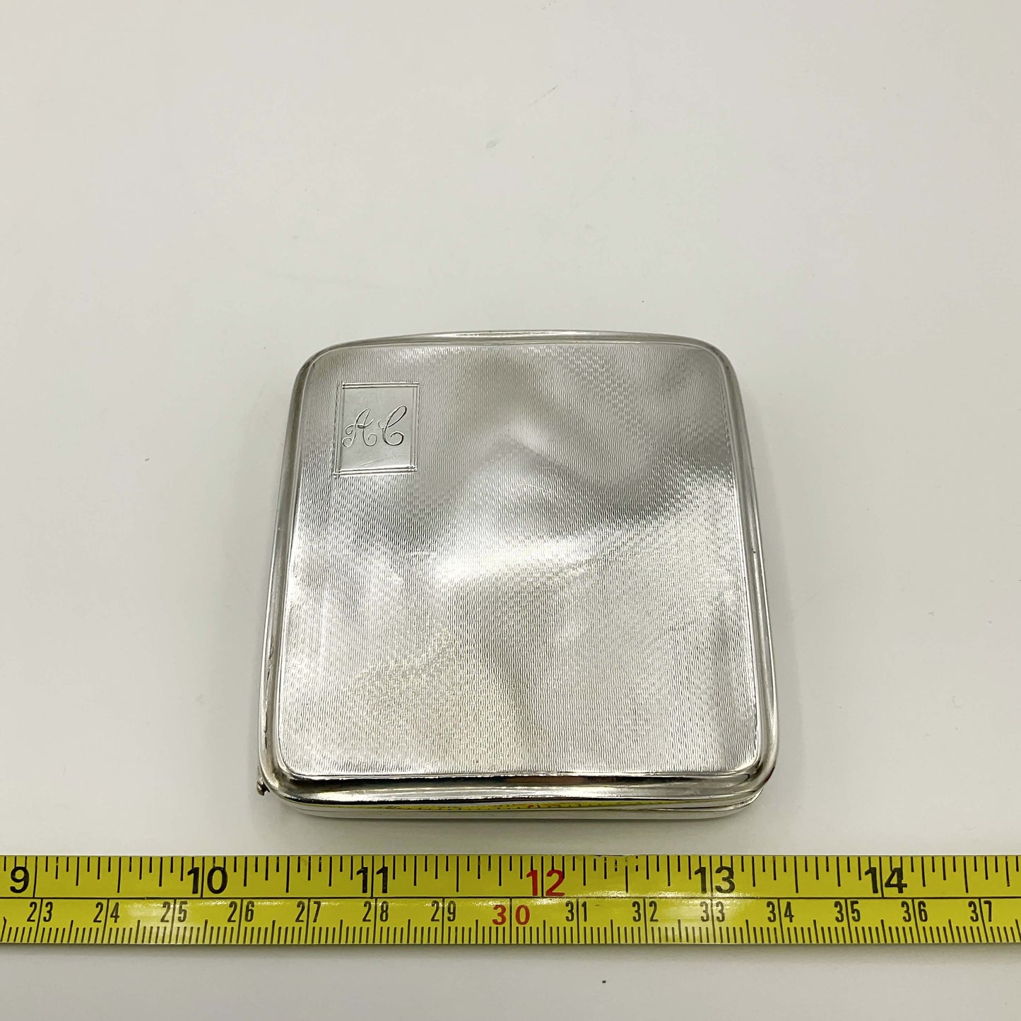 Silver Cigarette Case next to tape measure showing 8cm width