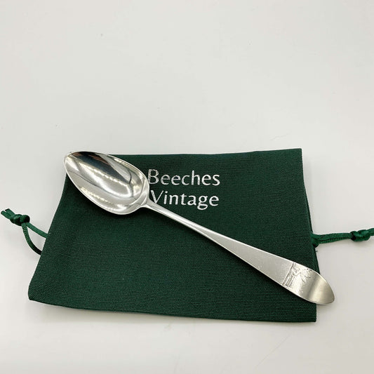 Antique Silver Dessert Spoon on a green gift bag