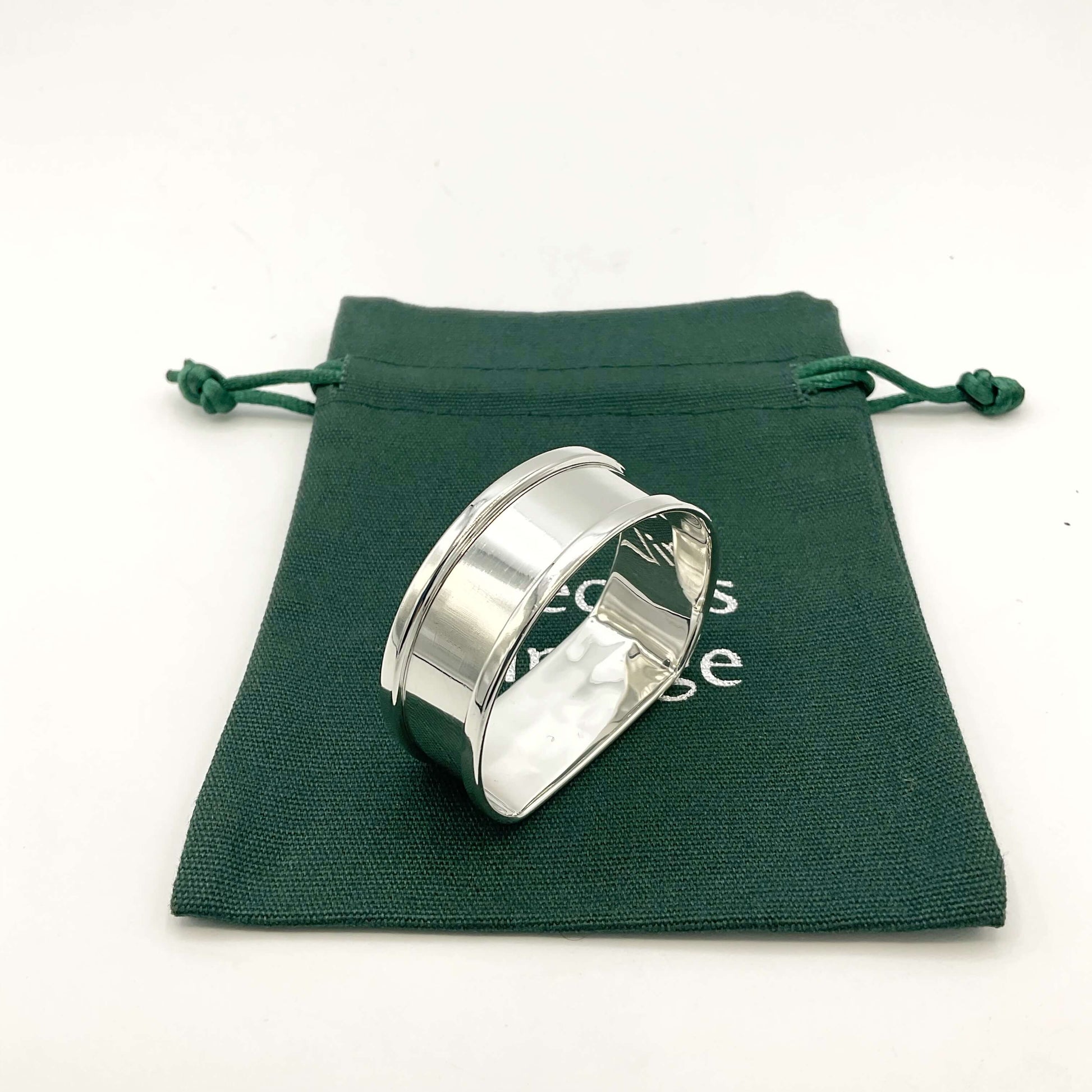 Vintage silver napkin ring on green gift bag on a white background 