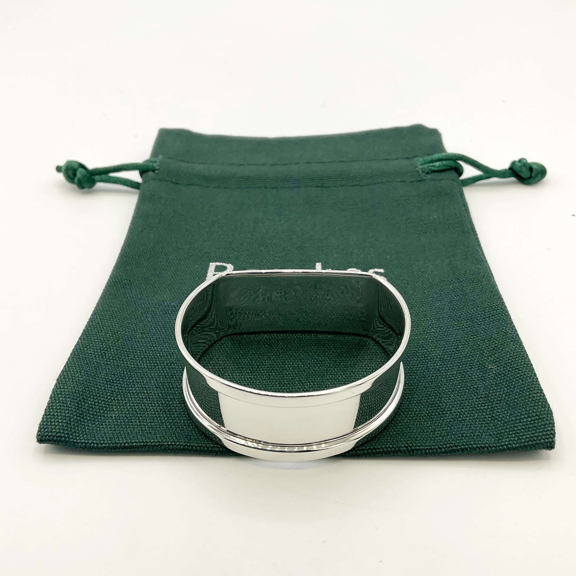 Vintage silver napkin ring on a green gift bag on a white background 