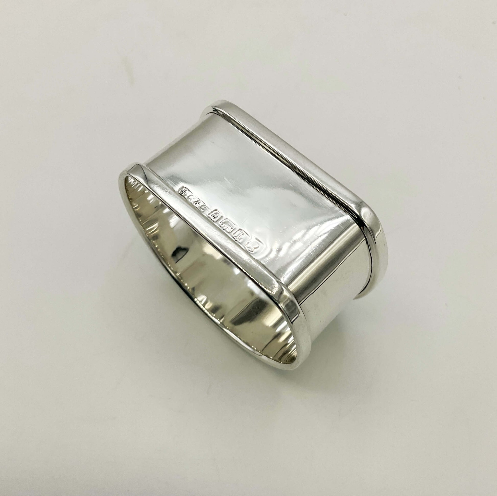 Upside down view of Vintage Silver napkin ring on a white background