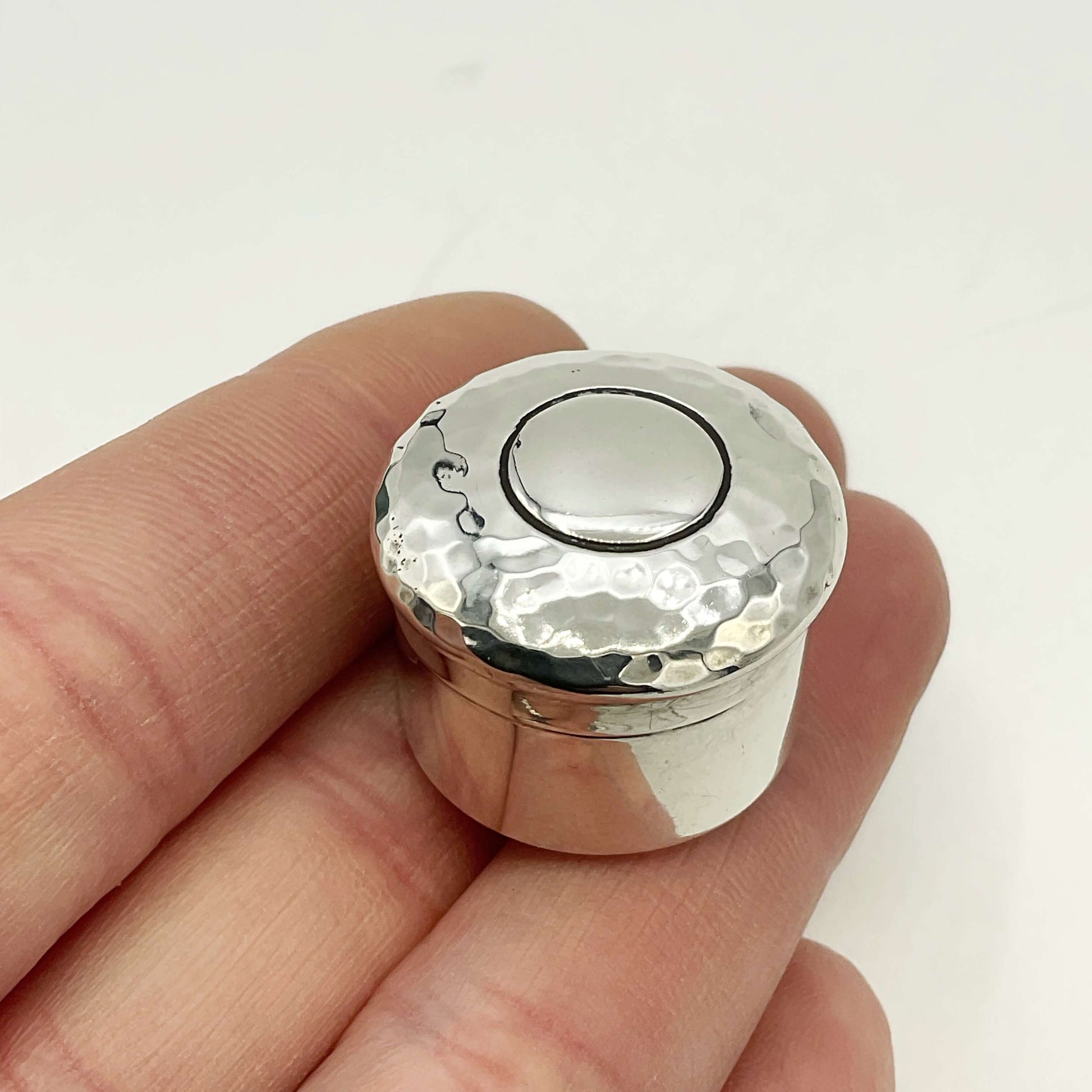 Antique silver pill box on a hand