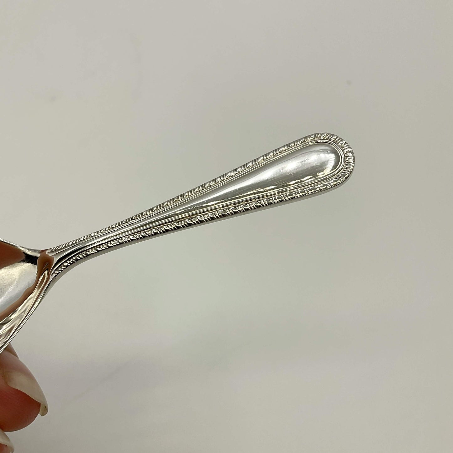 Handle of Sterling Silver Tea Caddy Spoon on a white background 
