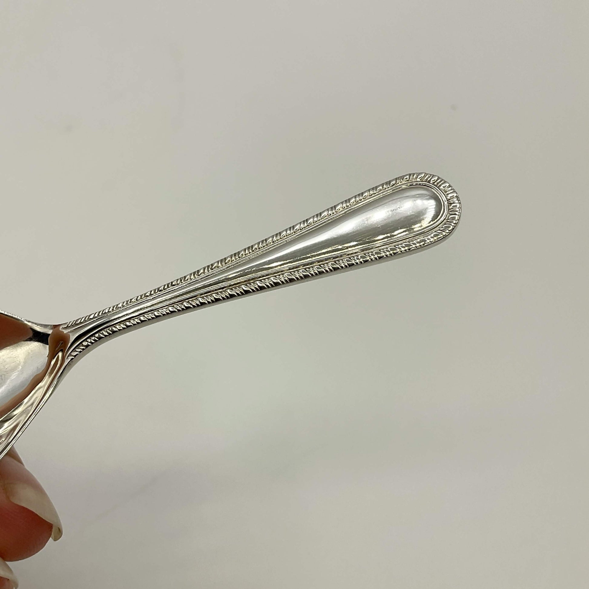 Handle of Sterling Silver Tea Caddy Spoon on a white background 