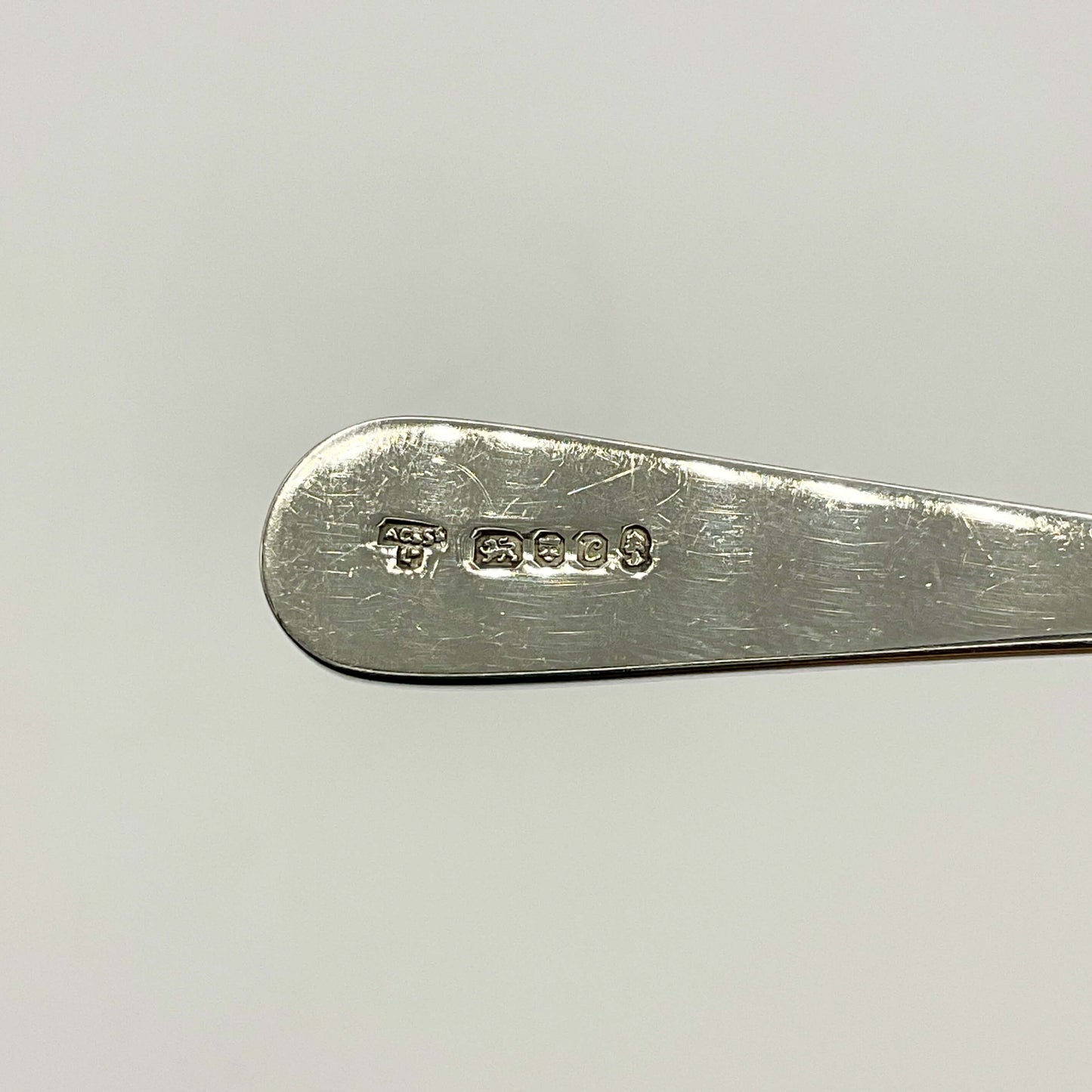 Back of Sterling Silver Tea Caddy Spoon handle showing the hallmarks on a white background 