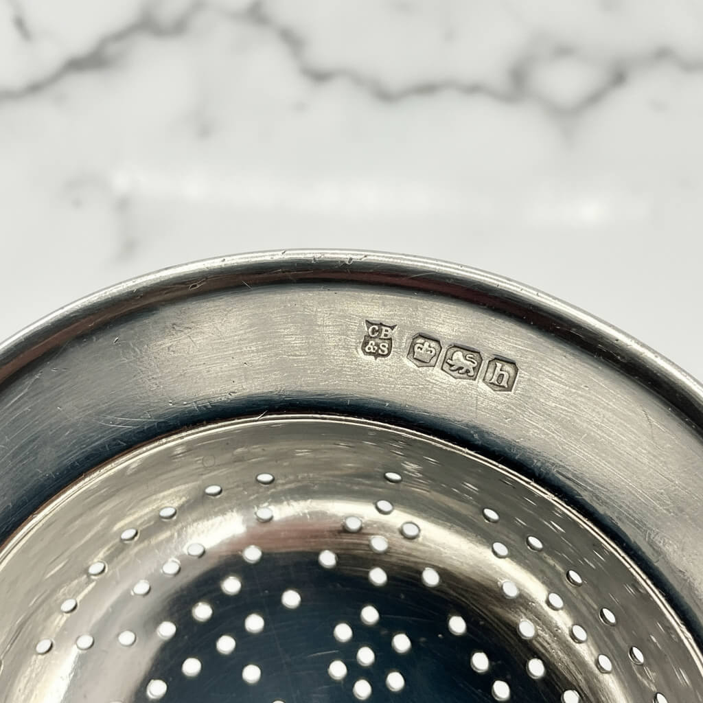 Antique 1925 sterling silver tea strainer with intricate details, crafted by Beeches Vintage, used for catching tea leaves during brewing.