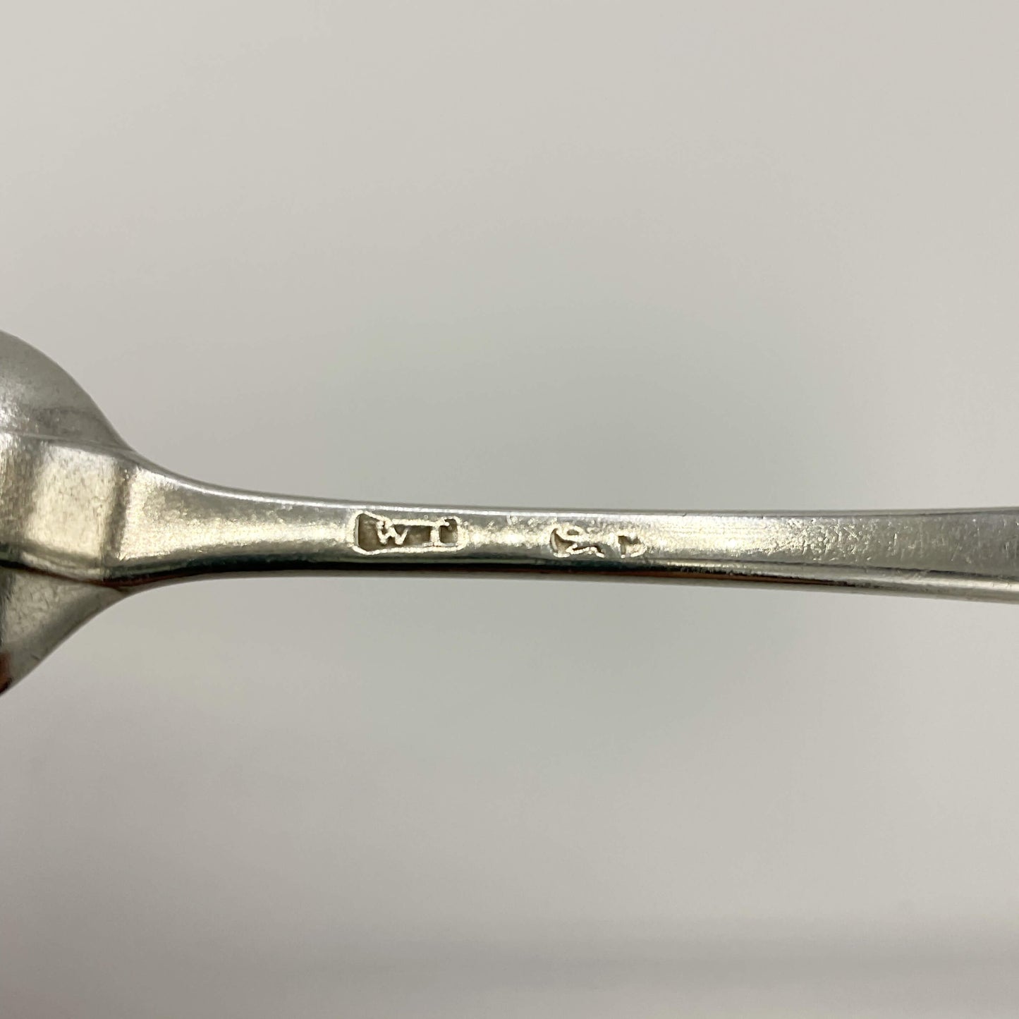 Hallmarks on back of Antique silver coffee spoon on a white background 