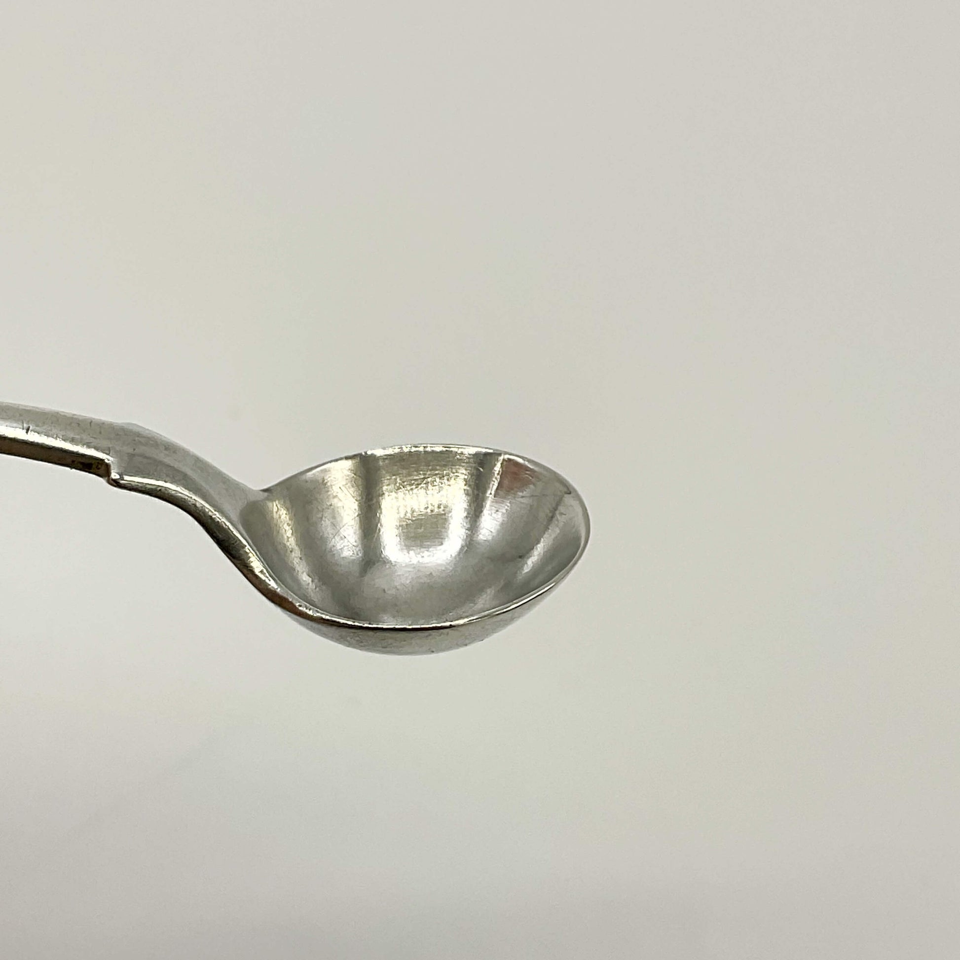 The bowl of an Antique silver salt spoon on a white background 