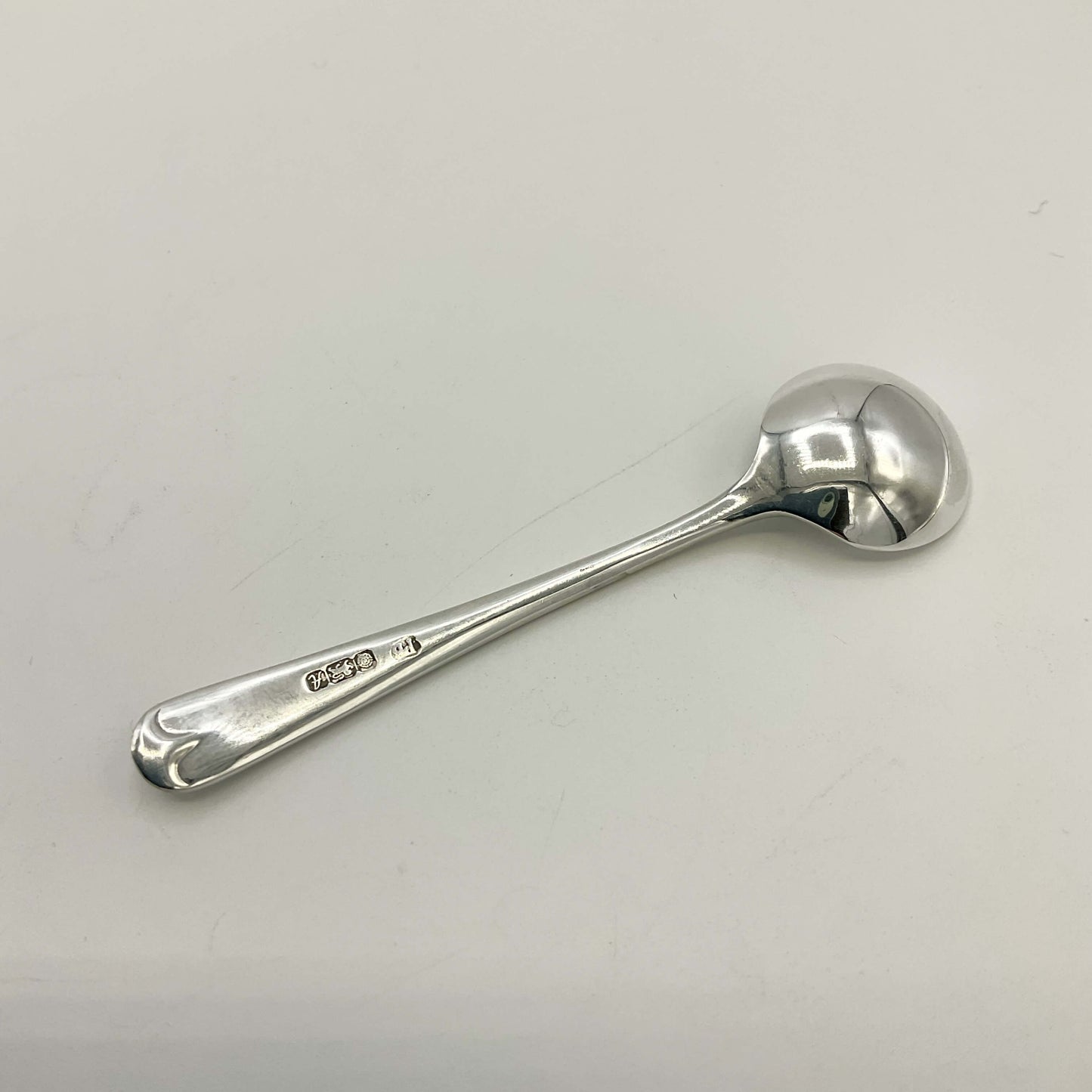 Back of Small silver salt spoon on a white background