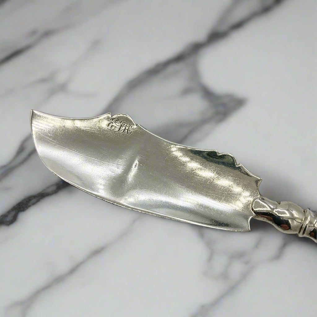 Antique Sterling Silver butter knife blade on a marble worktop 