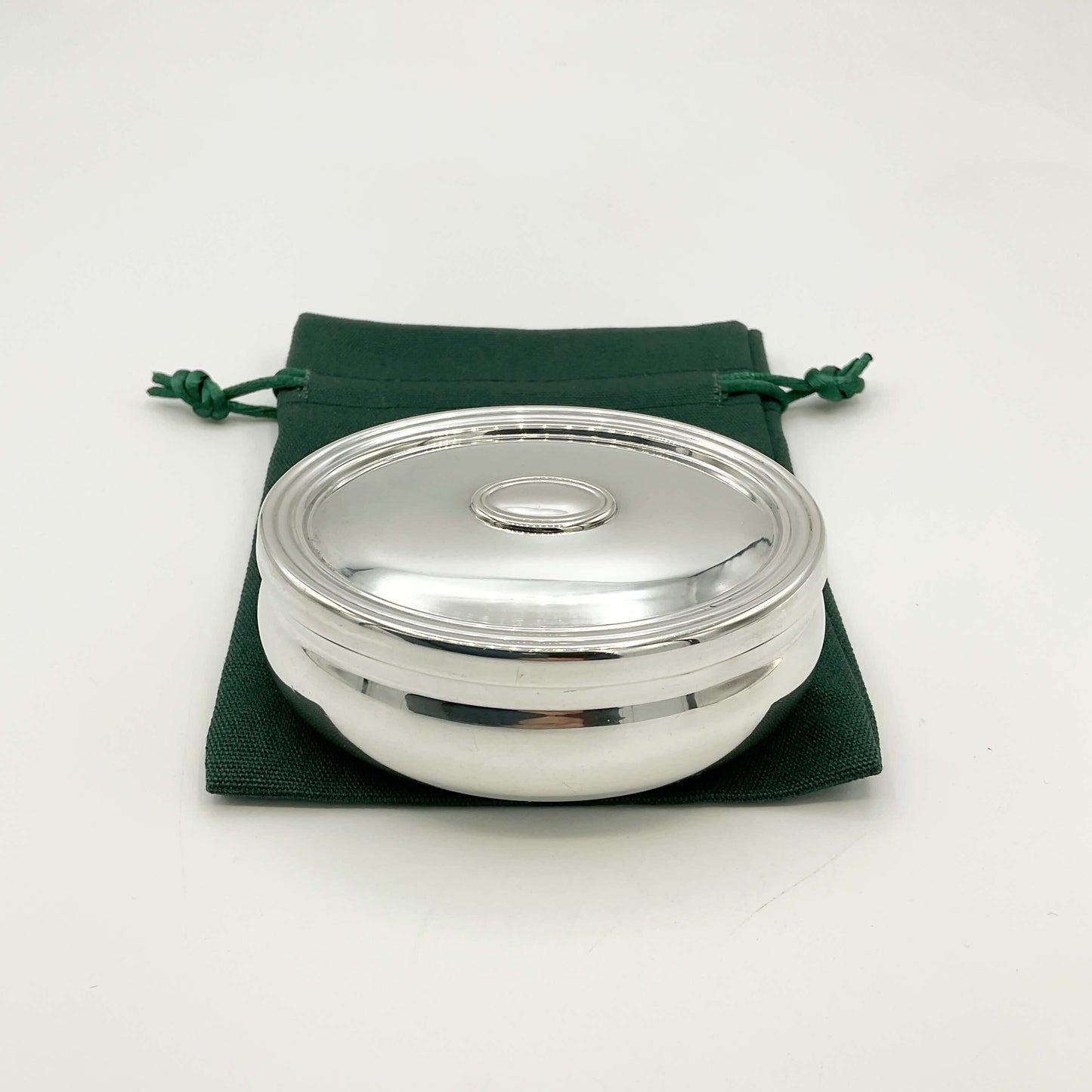Silver trinket box on a gren gift bag and white background 