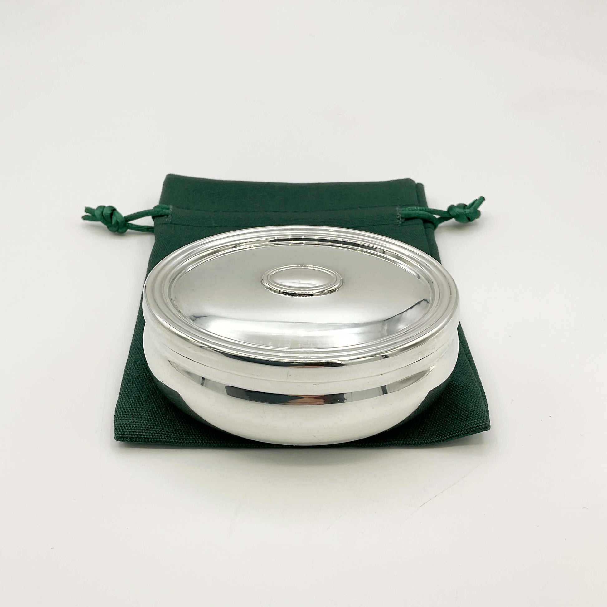 Silver trinket box on a gren gift bag and white background 