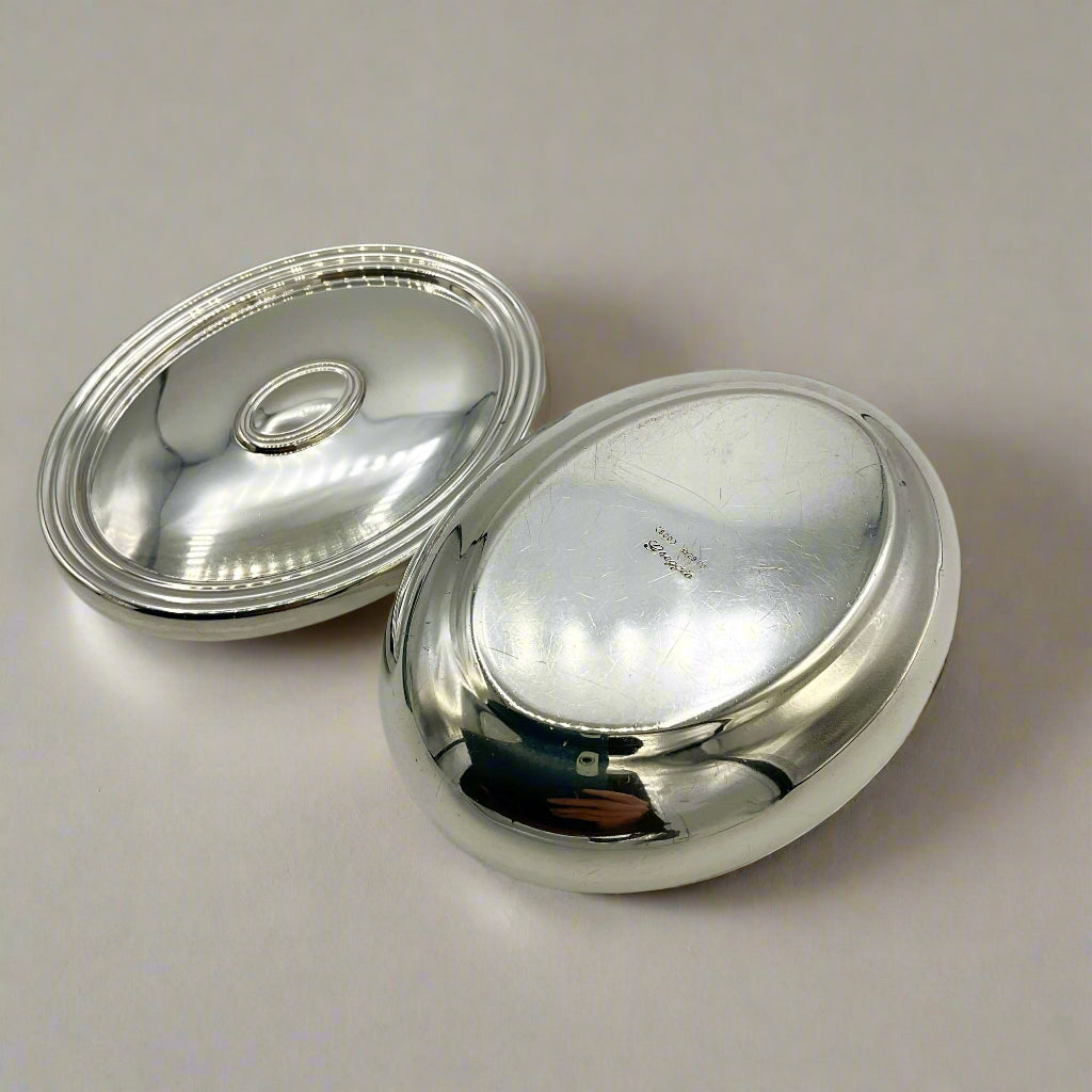 Base of a silver trinket box and li on a beige background 
