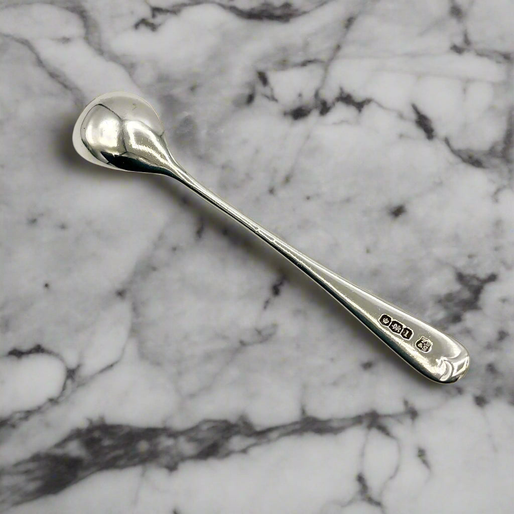 Back of silver salt spoon on a marble worktop