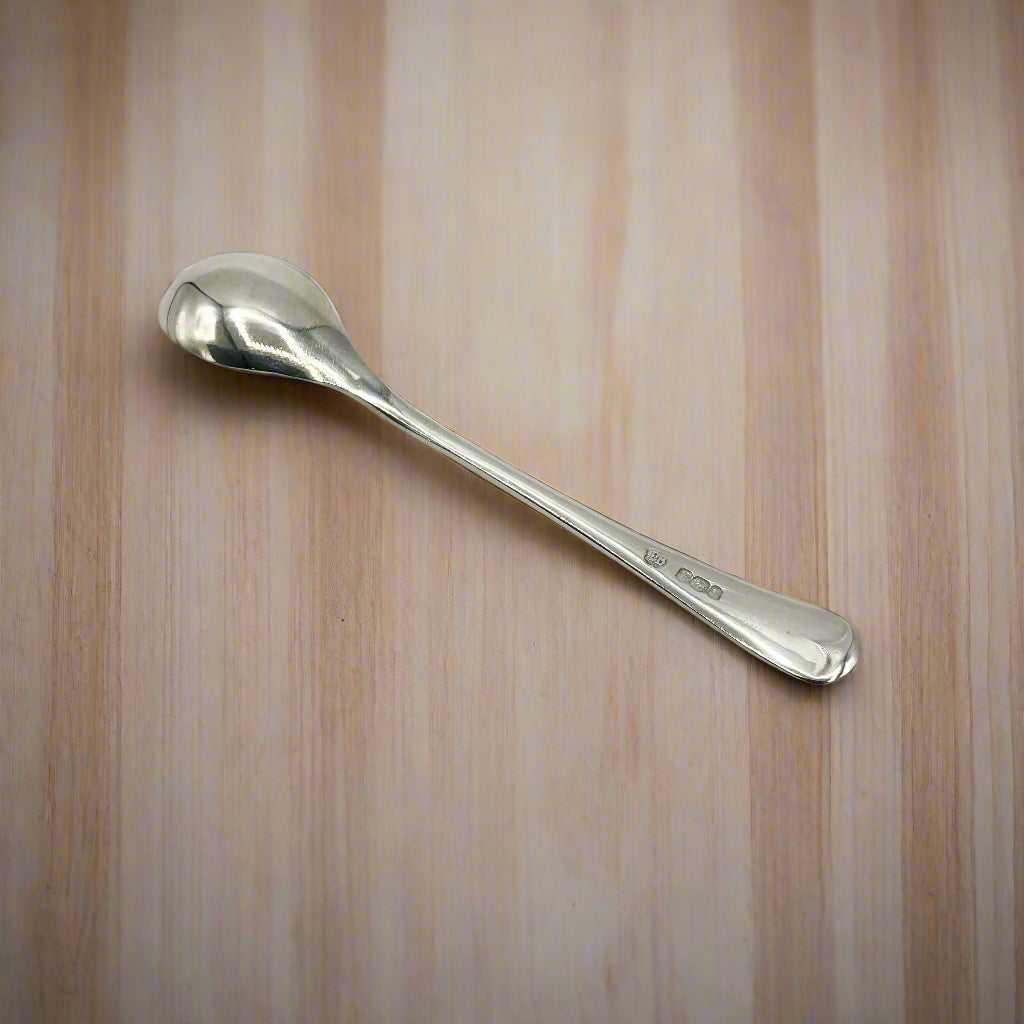 Back of Silver salt spoon on a wooden table