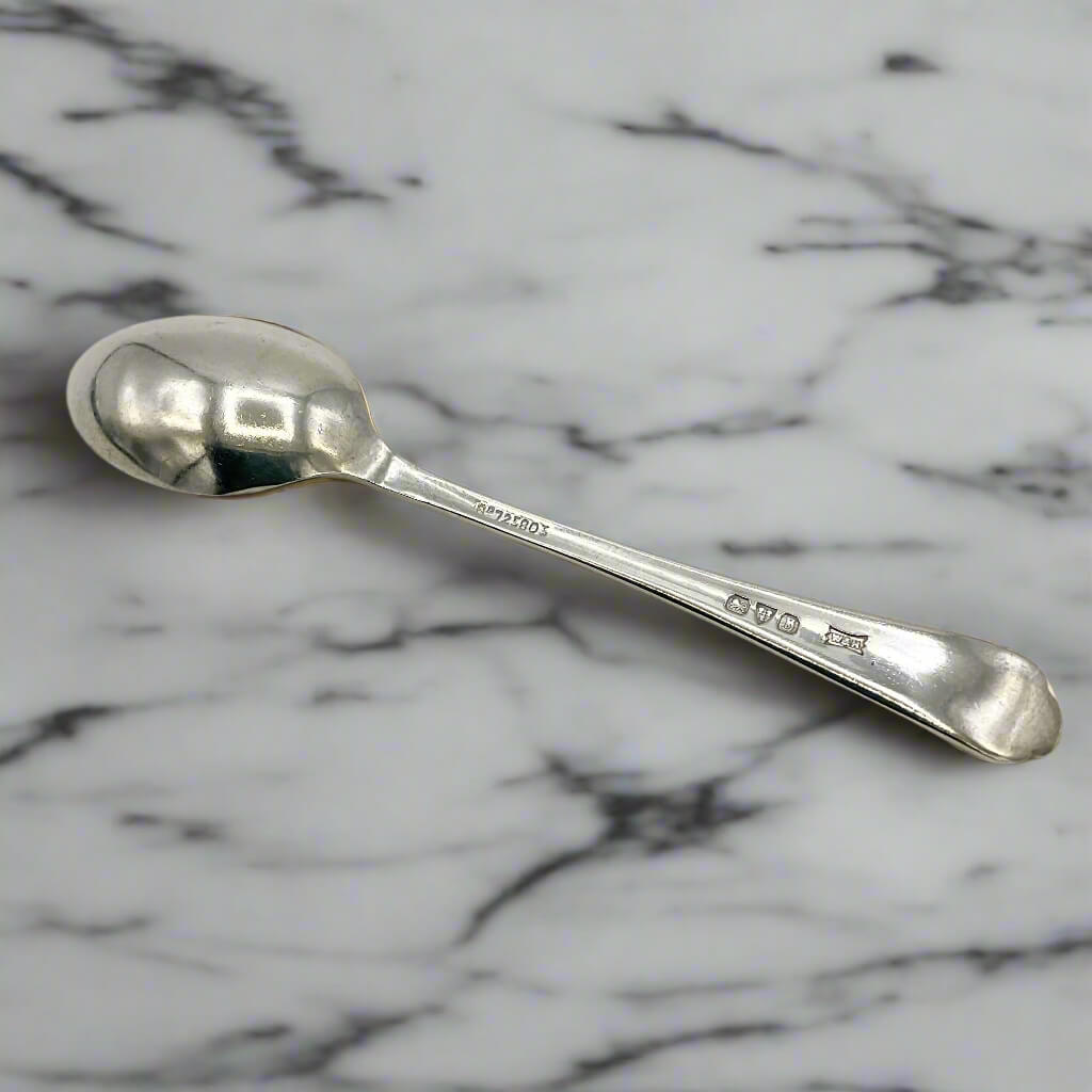 Back of Sterling silver coffee spoon on a marble worktop