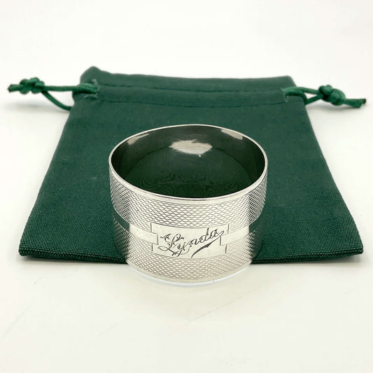 Silver napkin ring with Lynda on on the front on a gift bag on a white background 