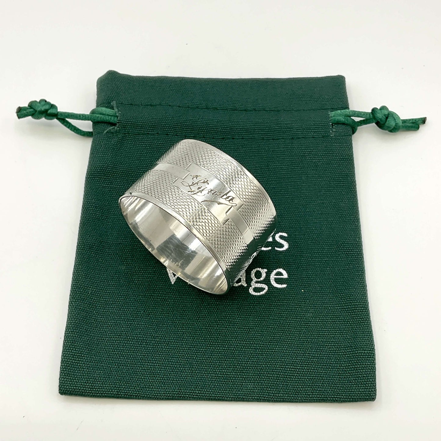 Silver napkin ring with Lynda on on the front on a gift bag on a white background 