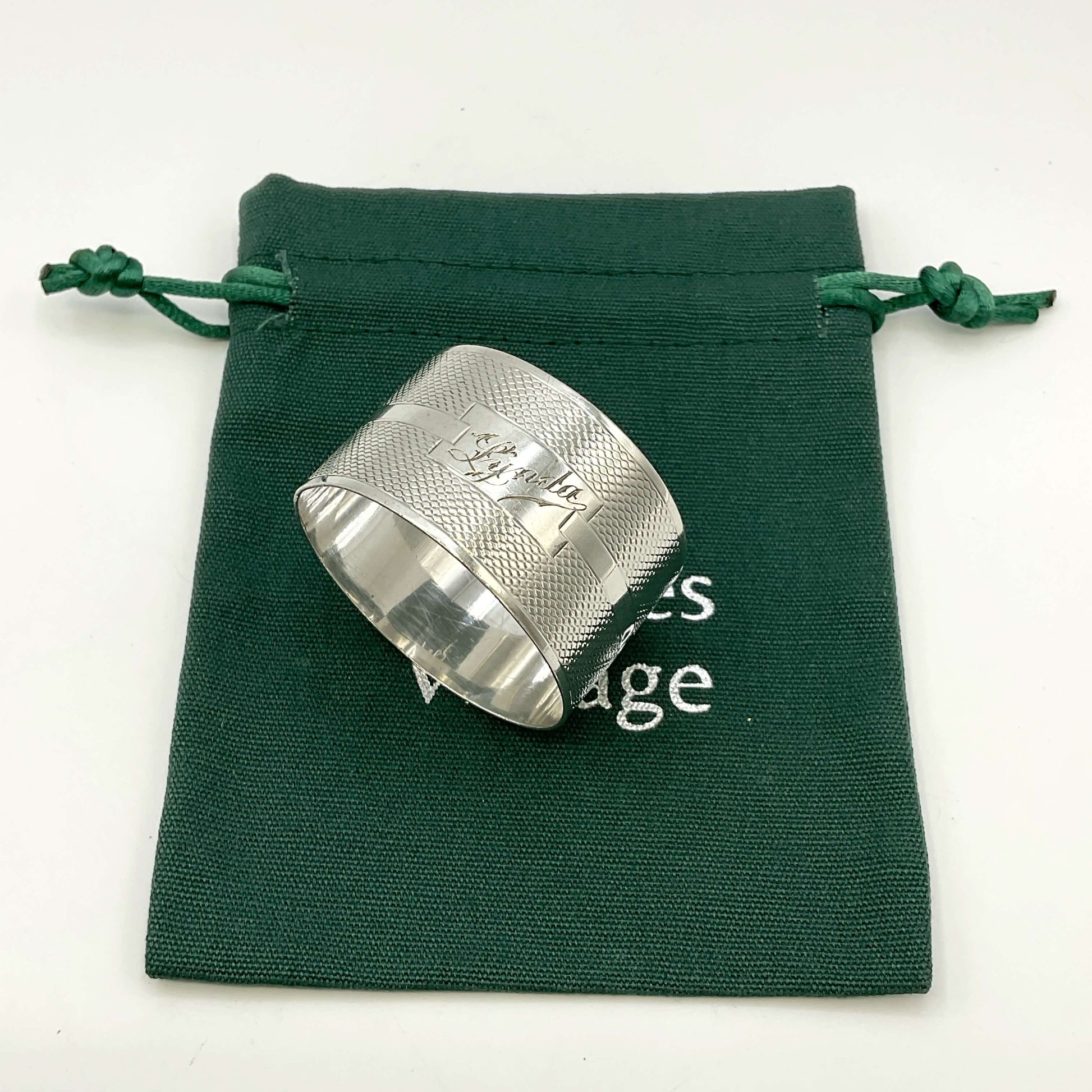 Silver napkin ring with Lynda on on the front on a gift bag on a white background 