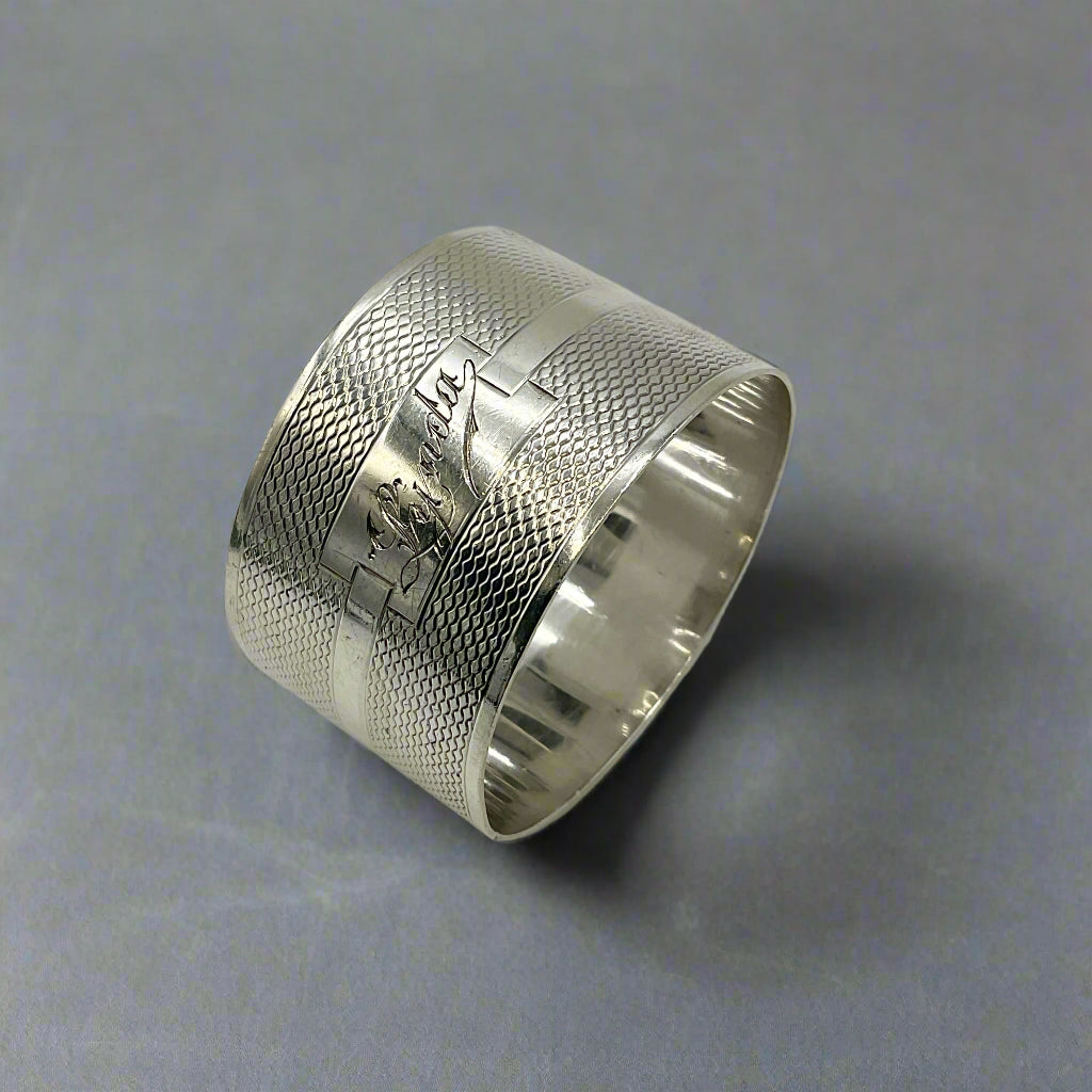 Silver napkin ring with Lynda engraved on the front on a grey granite worktop