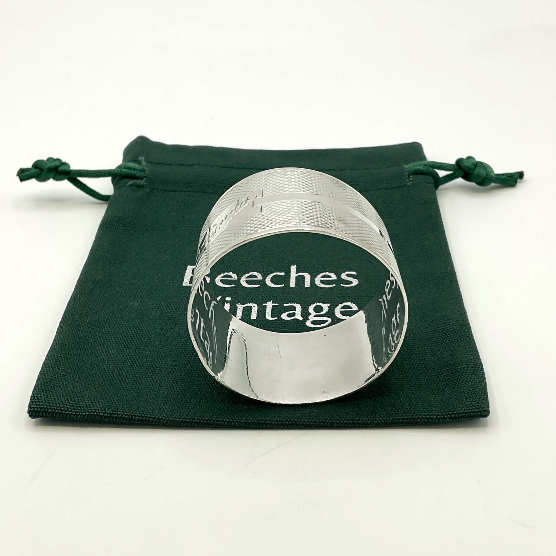 Silver napkin ring with Lynda on on the front on a gift bag on a white background 