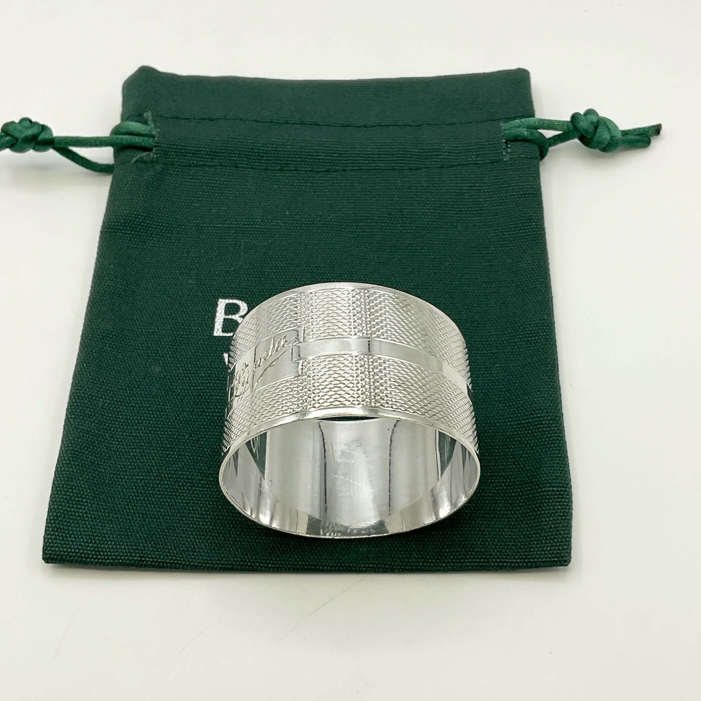 Silver napkin ring with Lynda on on the front on a gift bag on a white background 