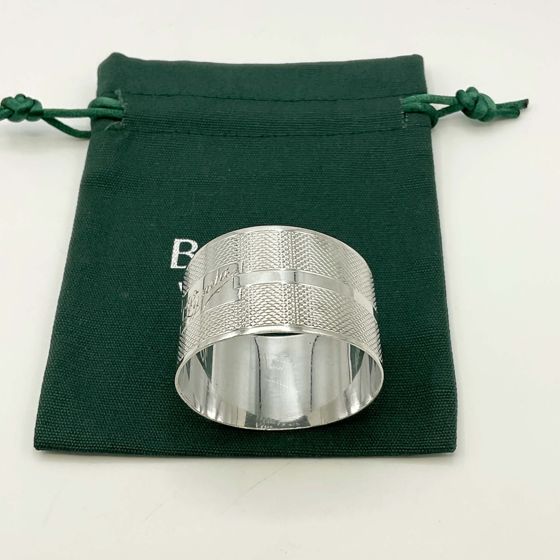 Silver napkin ring with Lynda on on the front on a gift bag on a white background 