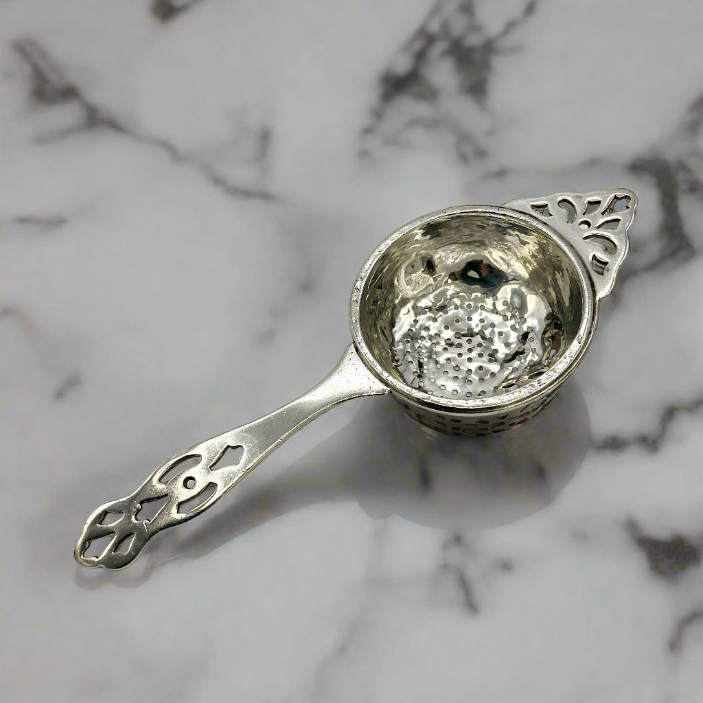Silver tea strainer n a marble worktop