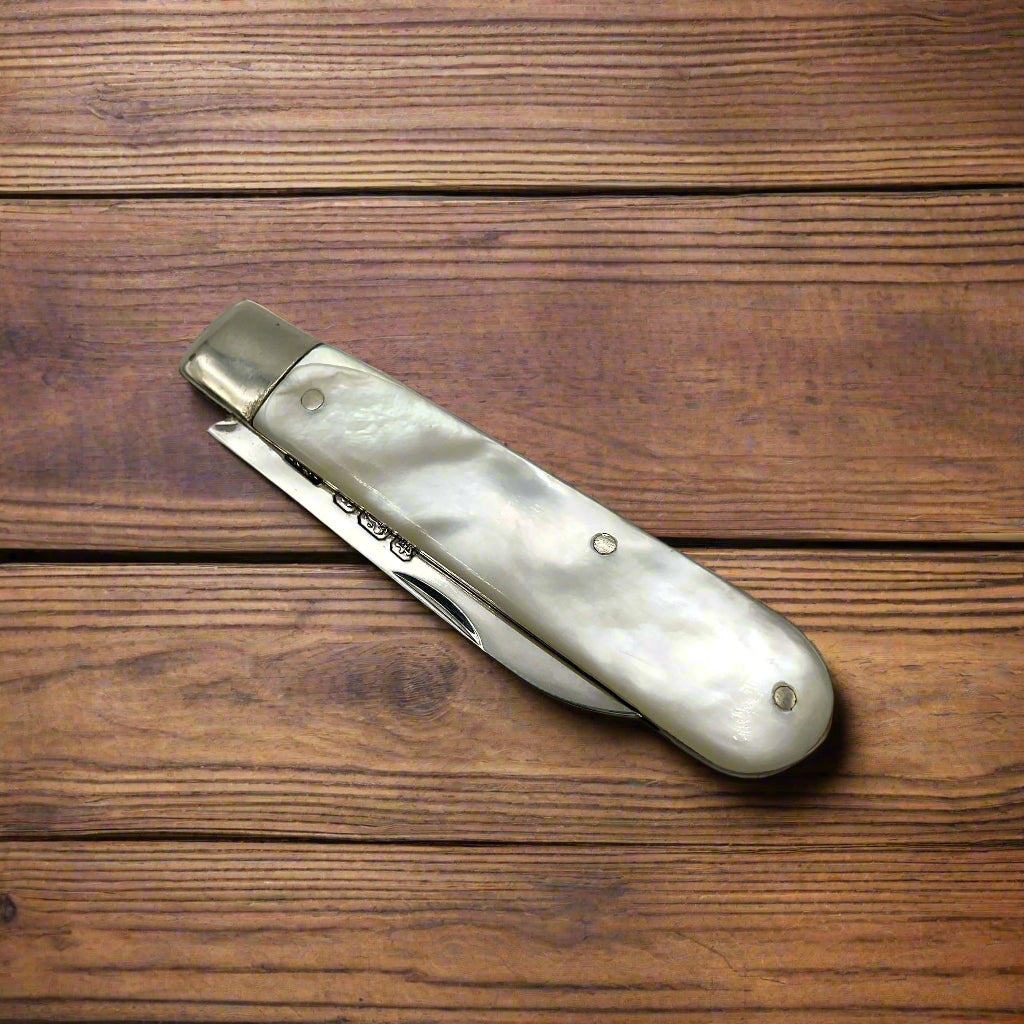 Folded fruit knife on a dark wood table